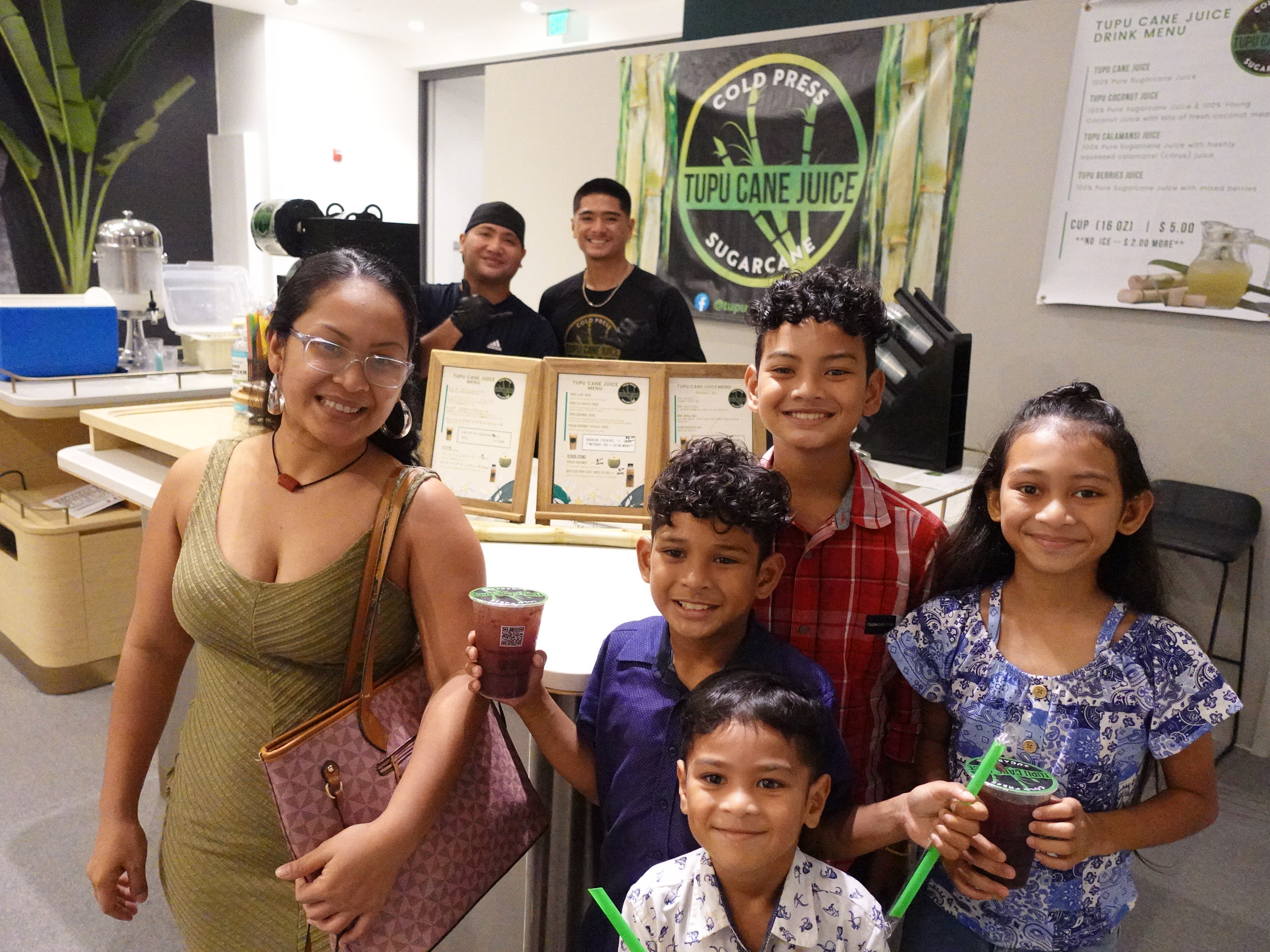 A family enjoys a variety of drinks from Tupu Cane Juice at the 19th Annual Christmas in the Marianas on Dec. 2, 2023, at T Galleria in Garapan, Saipan. 