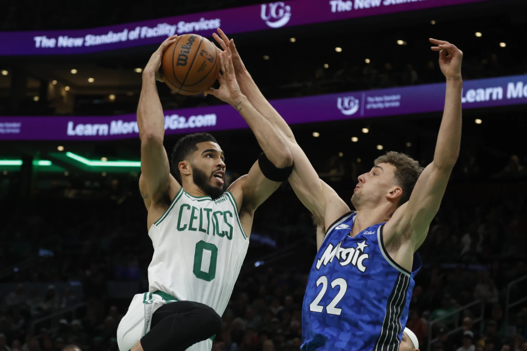 Boston Celtics forward Jayson Tatum (0) drives to the basket against Orlando Magic forward Franz Wagner (22) during the first half of an NBA game, Sunday, Dec. 17, 2023 in Boston.