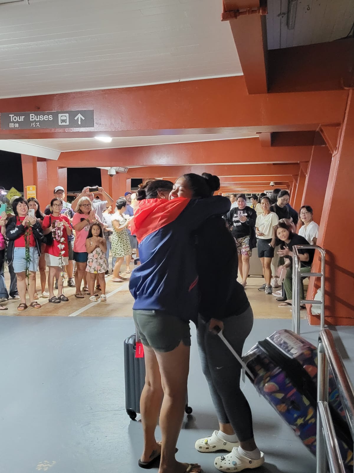 An NMI athlete receives a warm hug from a family member upon arrival at the Francisco C. Ada/Saipan International Airport on Sunday night.