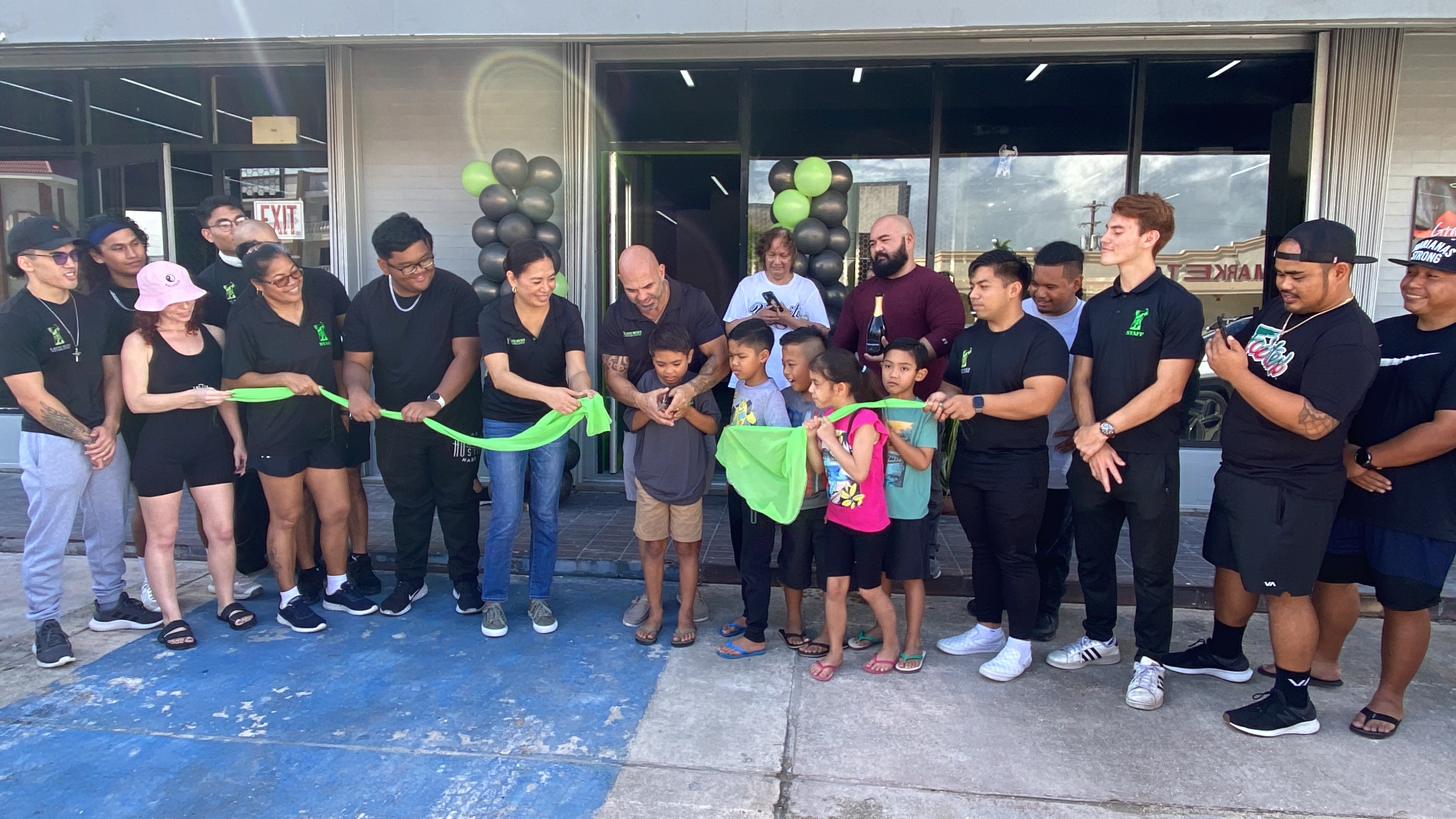 Derek Cutting, his family and staff cut the ceremonial ribbon for the new Latte Built location in Chalan Kanoa on Saturday, Dec. 9, 2023