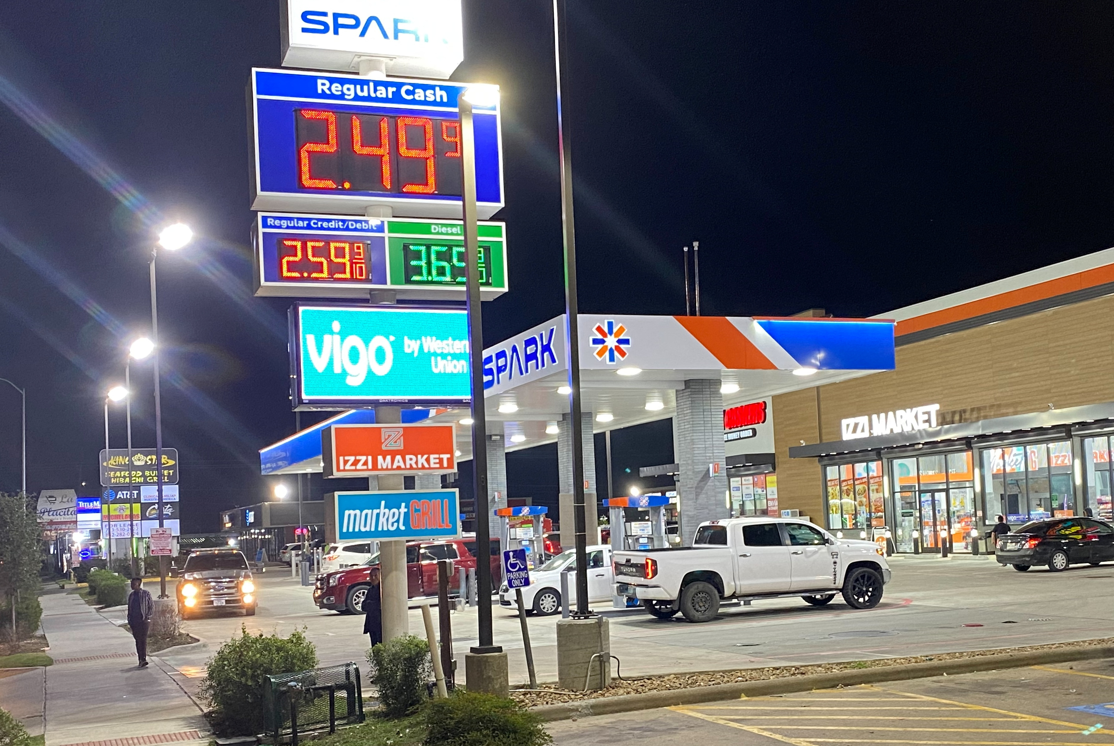 Signage shows the price of unleaded regular gas at less than $2.50 per gallon as cars queue to fill fuel at a gas station, in Houston, Texas, U.S., December 5, 2023. 