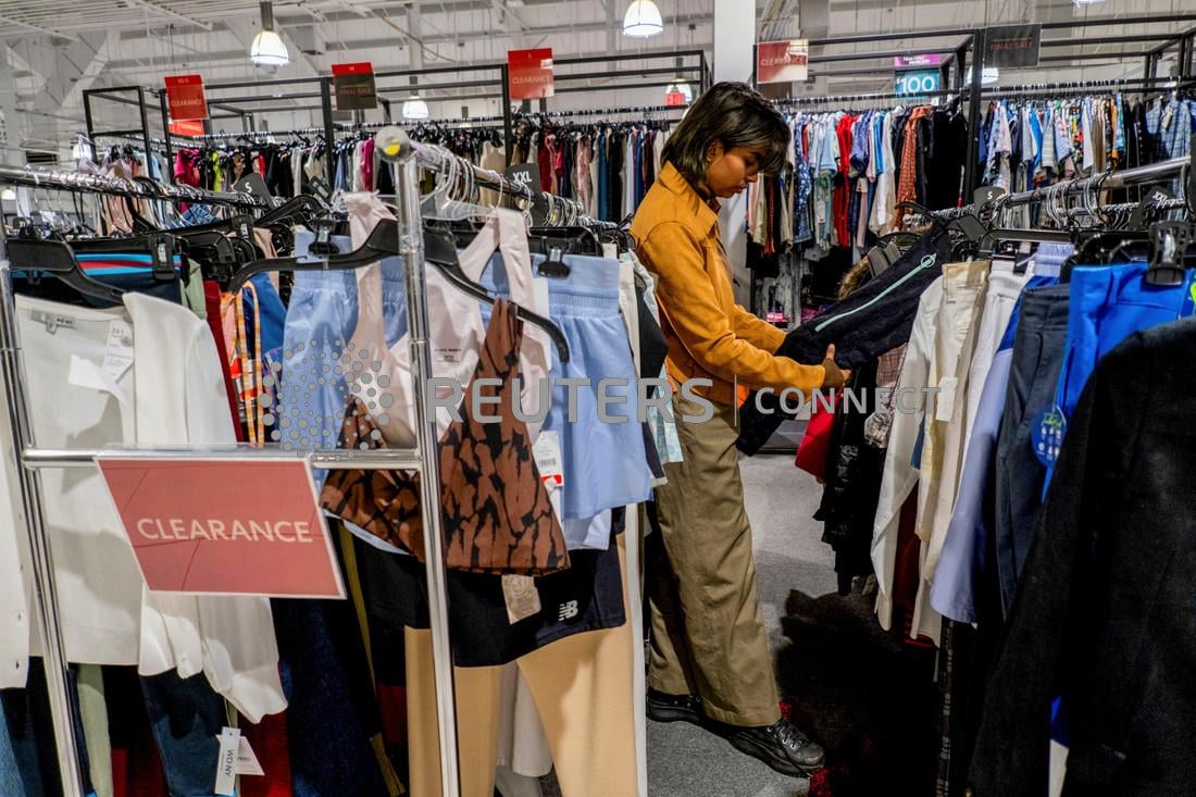 A person picks out clothing in a store as retailers compete to attract shoppers and try to maintain margins on Black Friday, one of the busiest shopping days of the year, at Woodbury Common Premium Outlets in Central Valley, New York, U.S. November 24, 2023. 