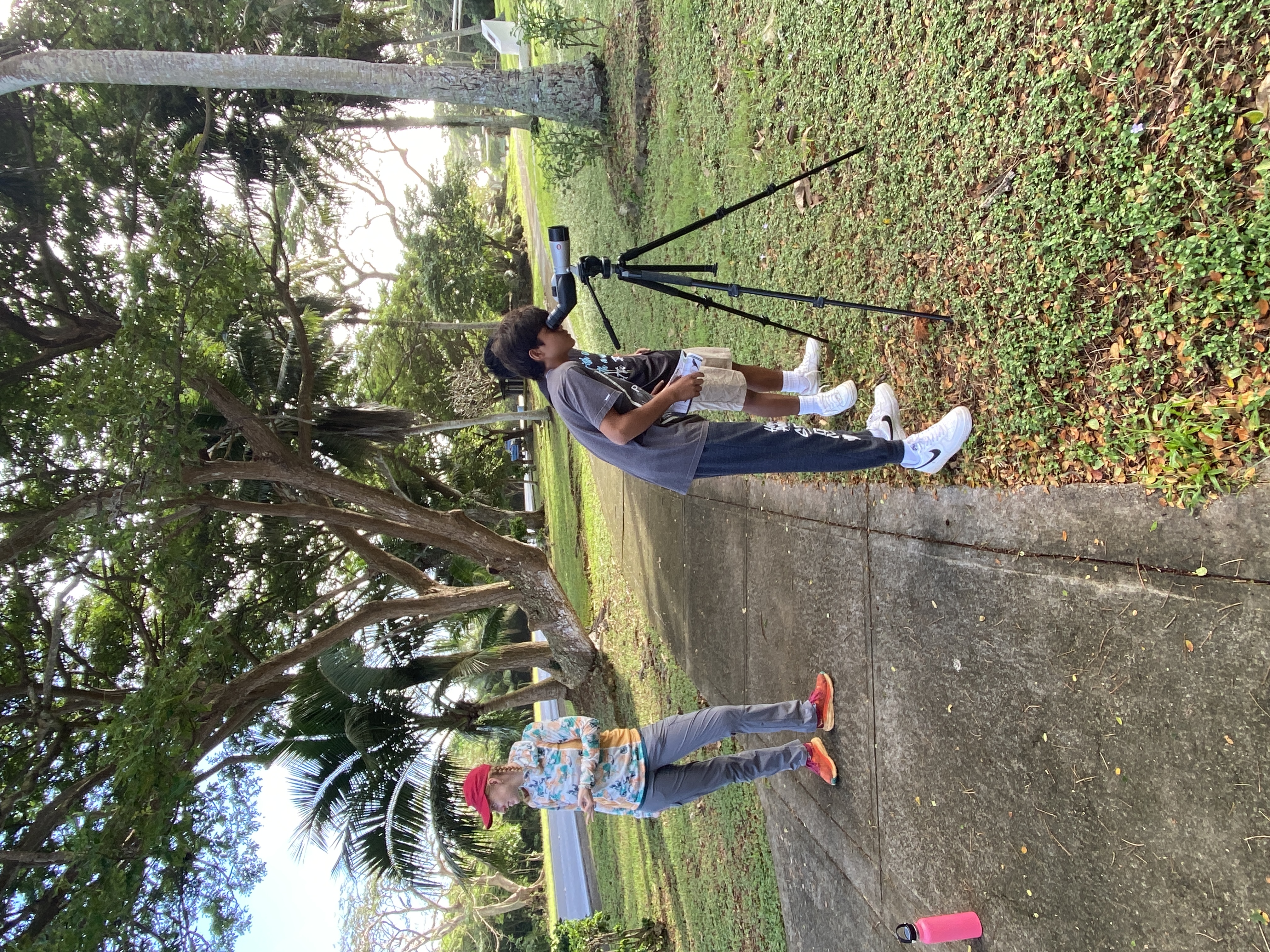 Students use a scope to view a bird off camera. Ellie Roark, left, speaks to students about ways to use a bird song to identify the birds in an area. 