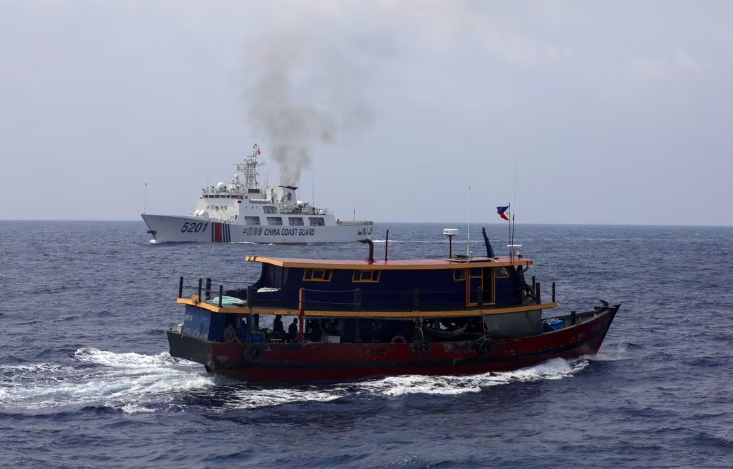 A Philippine supply boat sails near a Chinese Coast Guard ship during a resupply mission for Filipino troops stationed at a grounded warship in the South China Sea, Oct. 4, 2023.