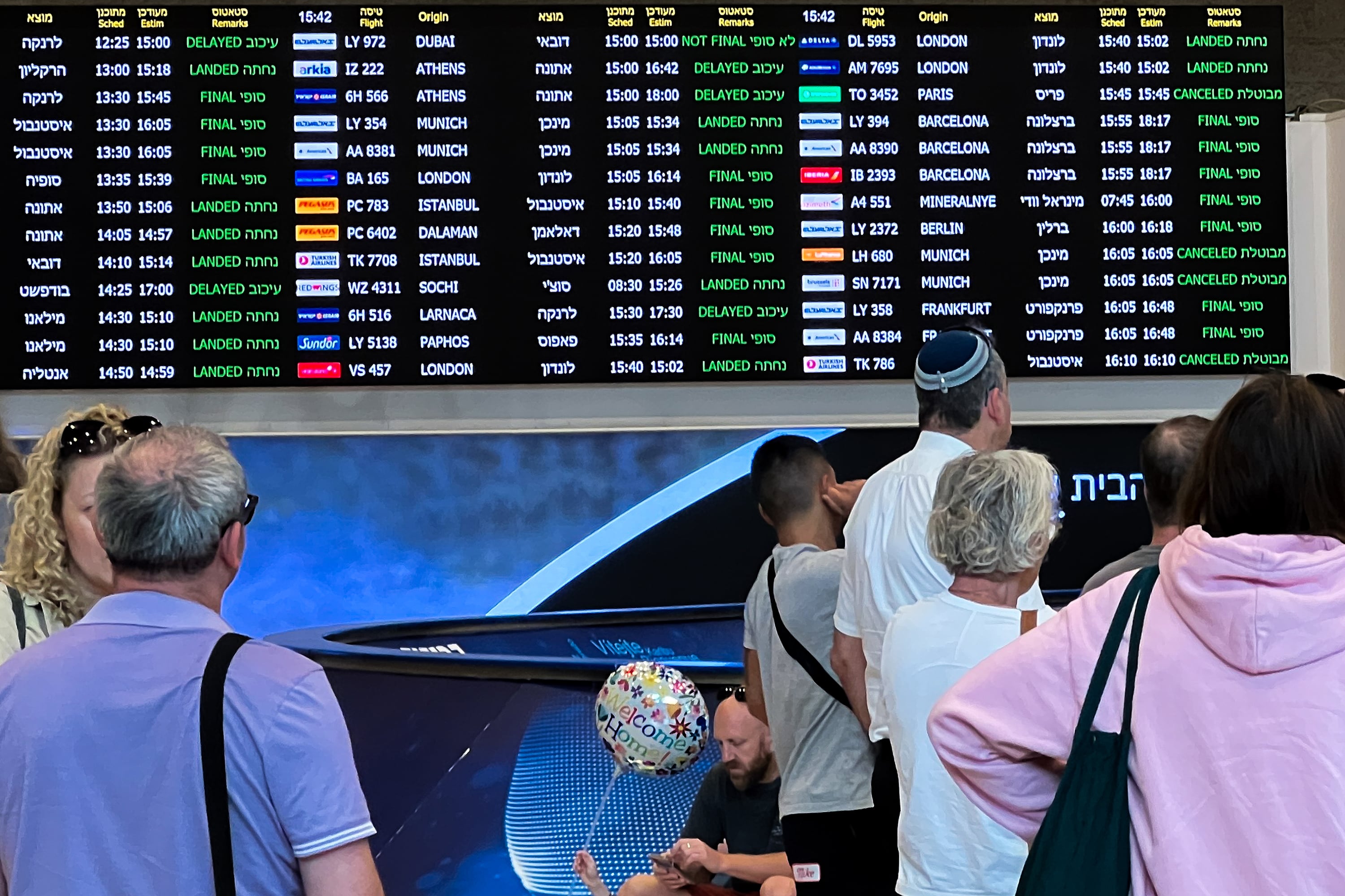 People wait for arriving passengers near flight status signage at Ben Gurion Airport on Oct. 9, 2023, in Lod, Israel. (Alexi J. Rosenfeld/Getty Images/TNS)