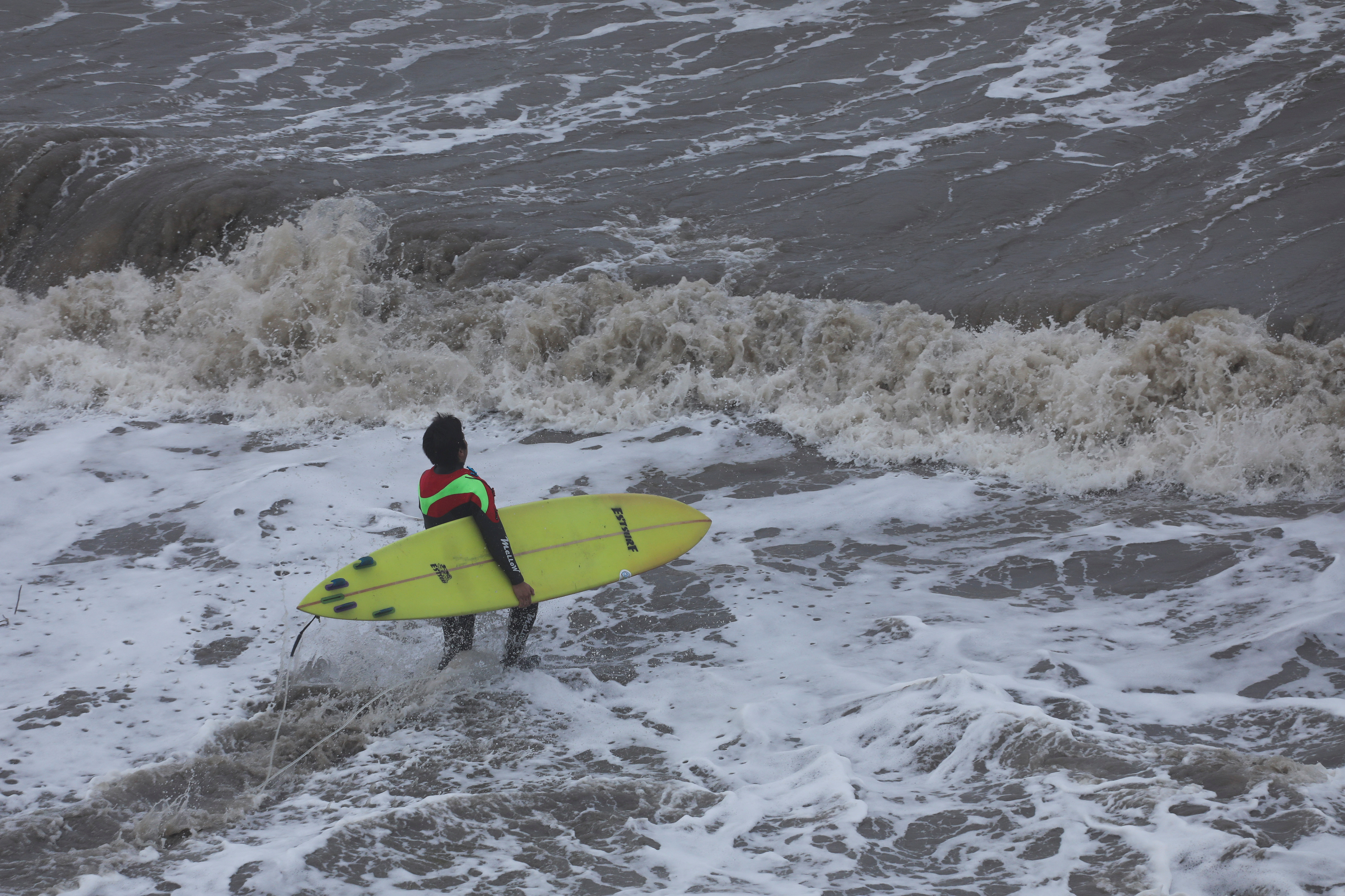 A surfer enters the water at the Mavericks Beach near the Half Moon Bay, California, U.S. December 28, 2023. 