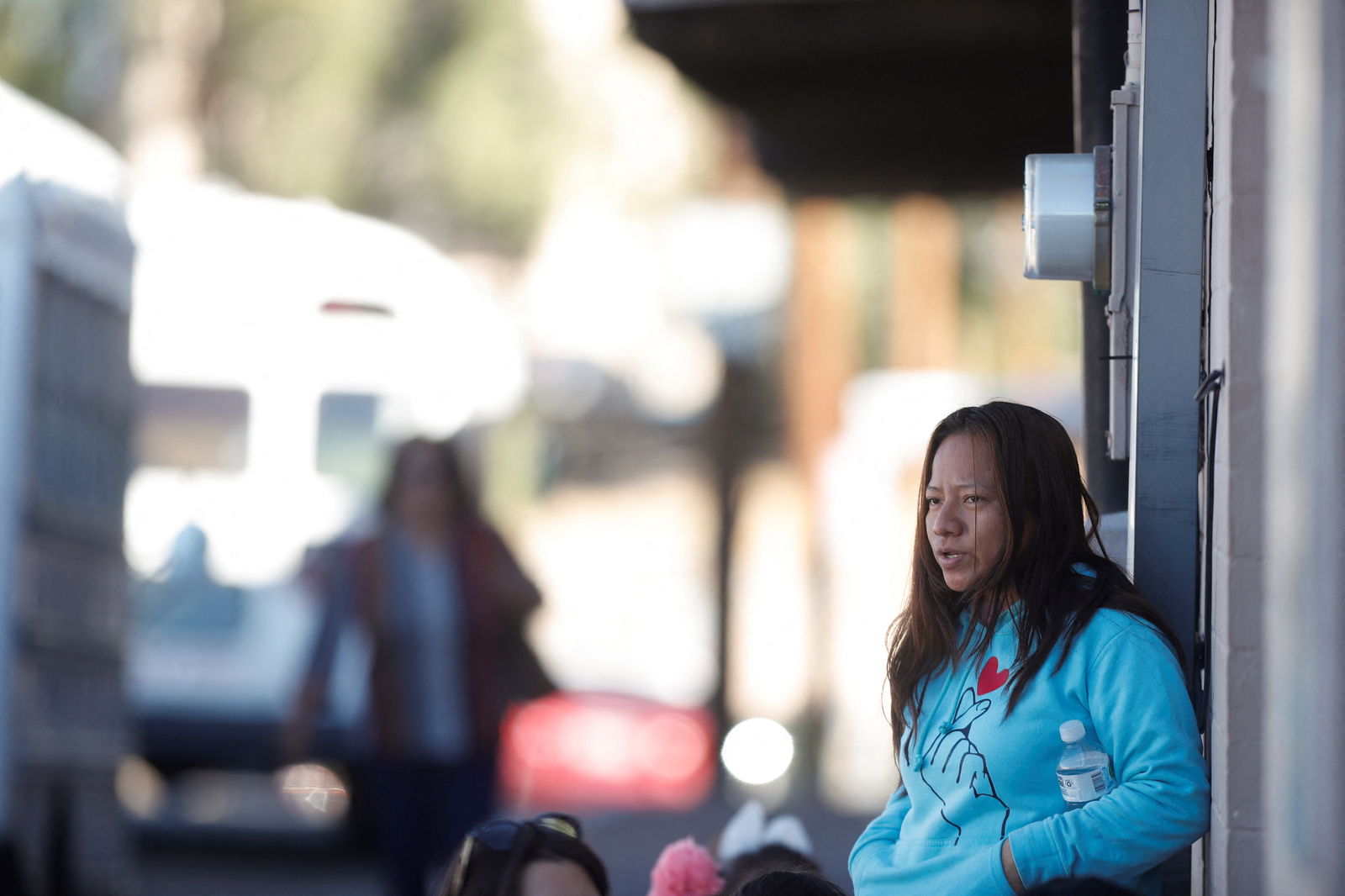 Yomara, 26, a Mexican migrant from Chiapas, waits with her family to be transported to a shelter after being processed, as Mexican families continue to be displaced by cartel violence and are requesting asylum in the U.S., in Nogales, Arizona, U.S. November 11, 2023. 