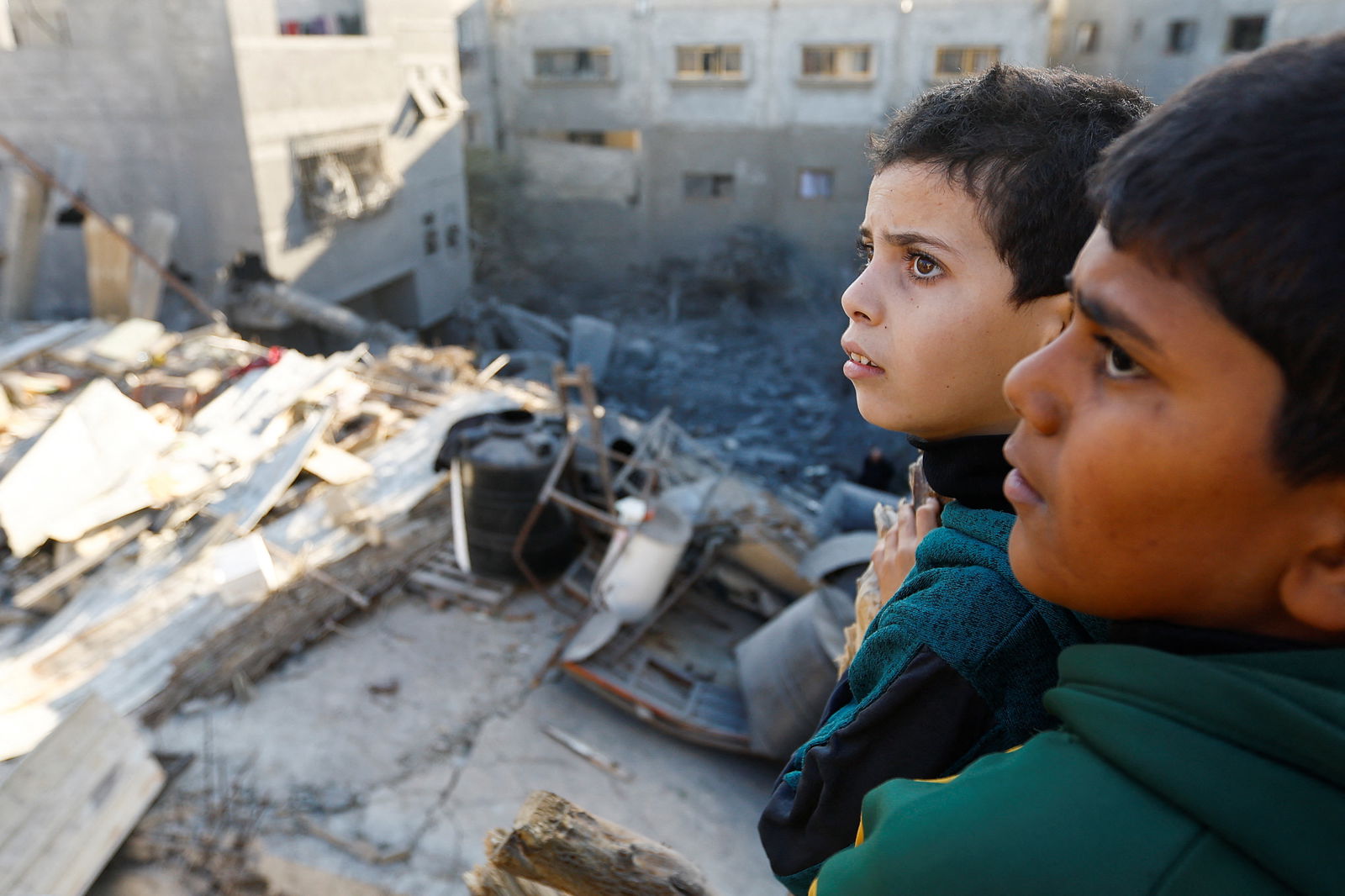 Palestinian children look at the damage at the site of Israeli strikes on houses, amid the ongoing conflict between Israel and the Palestinian Islamist group Hamas, in Khan Younis in the southern Gaza Strip, December 10, 2023. 