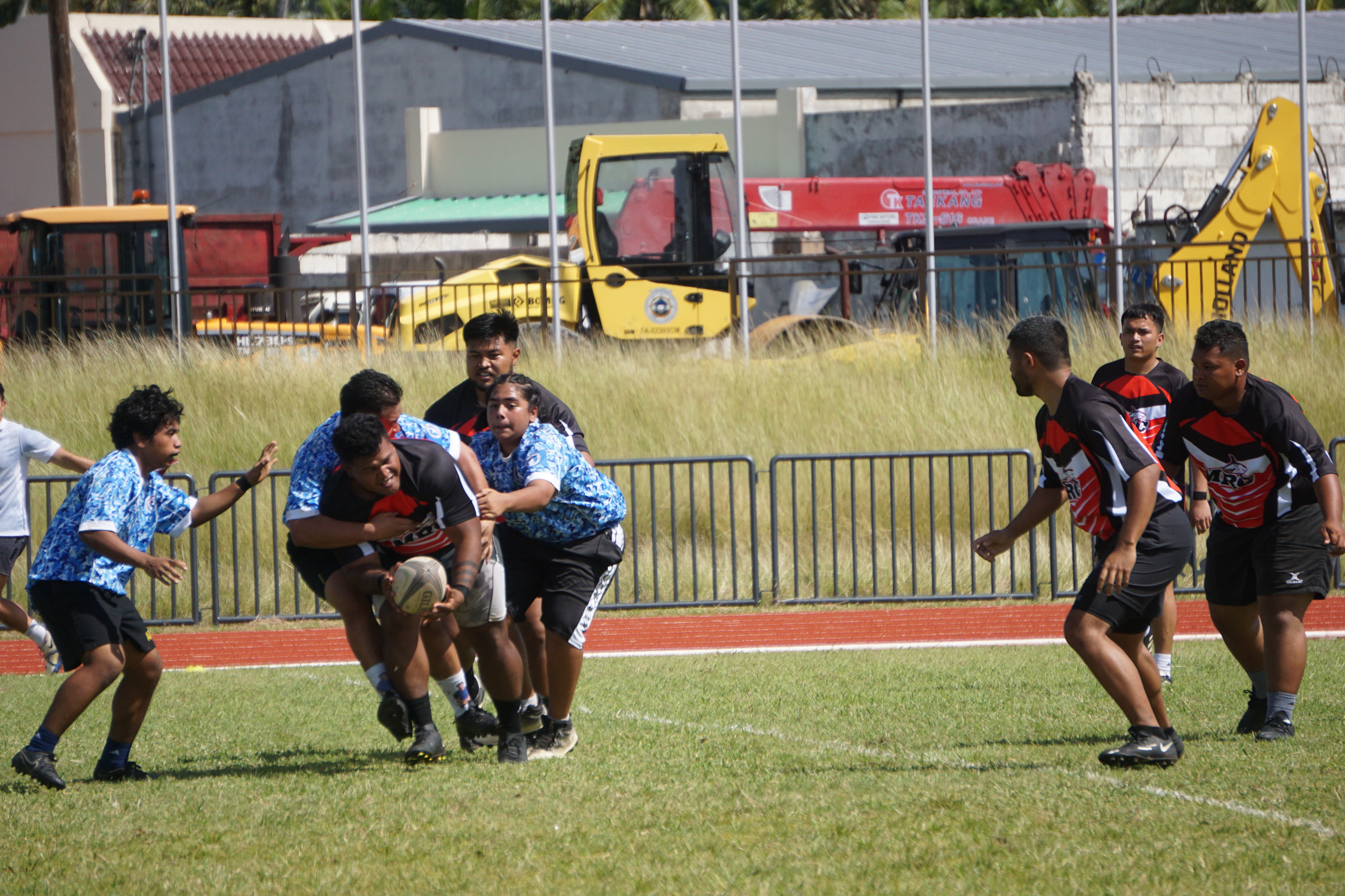 Marianas Rugby Club varsity's Brad Fritz attempts a pass as he gets taken down by junior varsity players Jesse Olopai and Hayden Igisomar during the first-ever Marianas Rugby Cup at the Oleai Sports Complex on Saturday. 