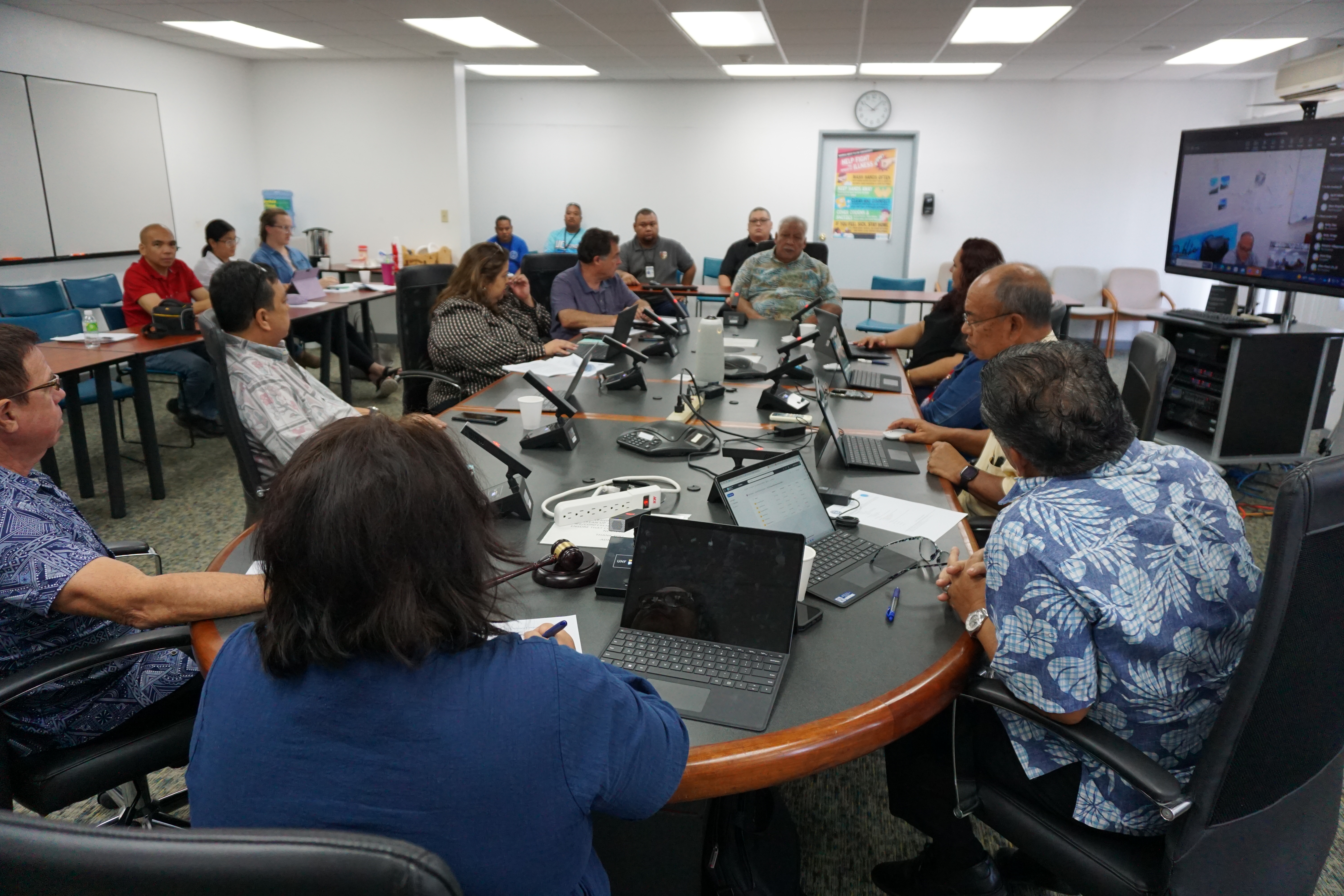 Rep. Roman Benavente, center background, urges the Commonwealth Utilities Corp. board of directors to find a way to lower utility costs during a meeting on Thursday.                                