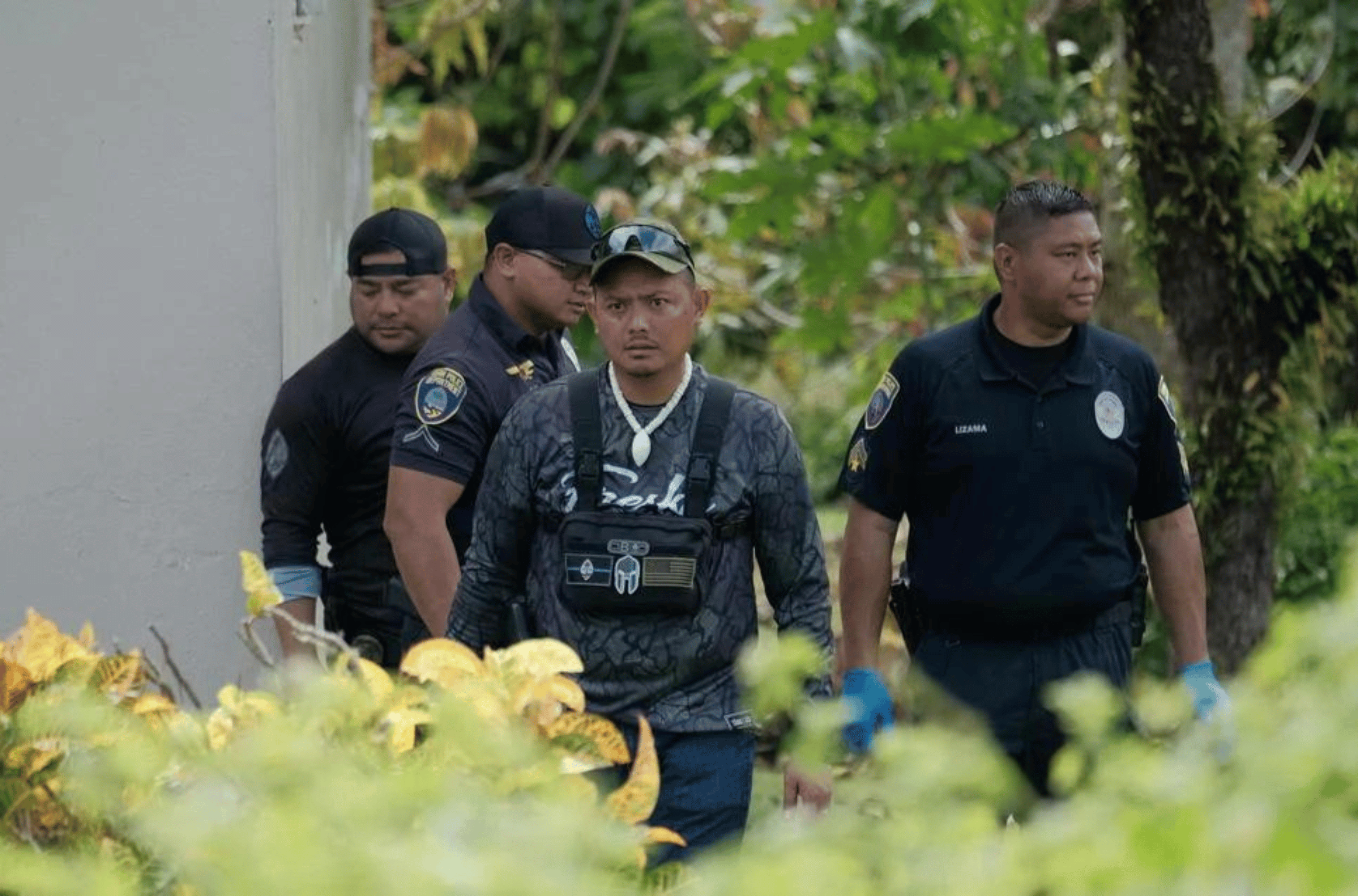 Guam Police Department detectives convene Saturday, Dec. 23, 2023, at a residence on Dimas Street in Mangilao where a body was discovered. 