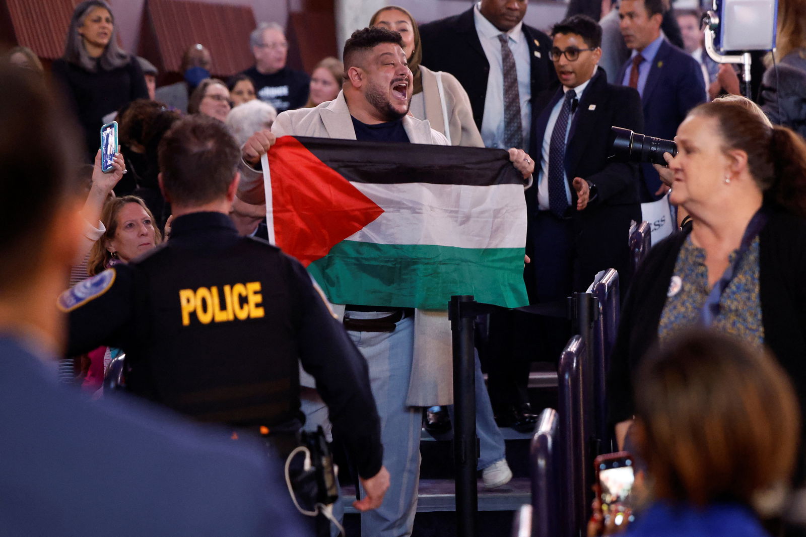 A protestors holds a Palestinian flag at the Hylton Performing Arts Center, as U.S. President Joe Biden attends a campaign event at the performing arts center focusing on abortion rights, in Manassas, Virginia, U.S., January 23, 2024. 