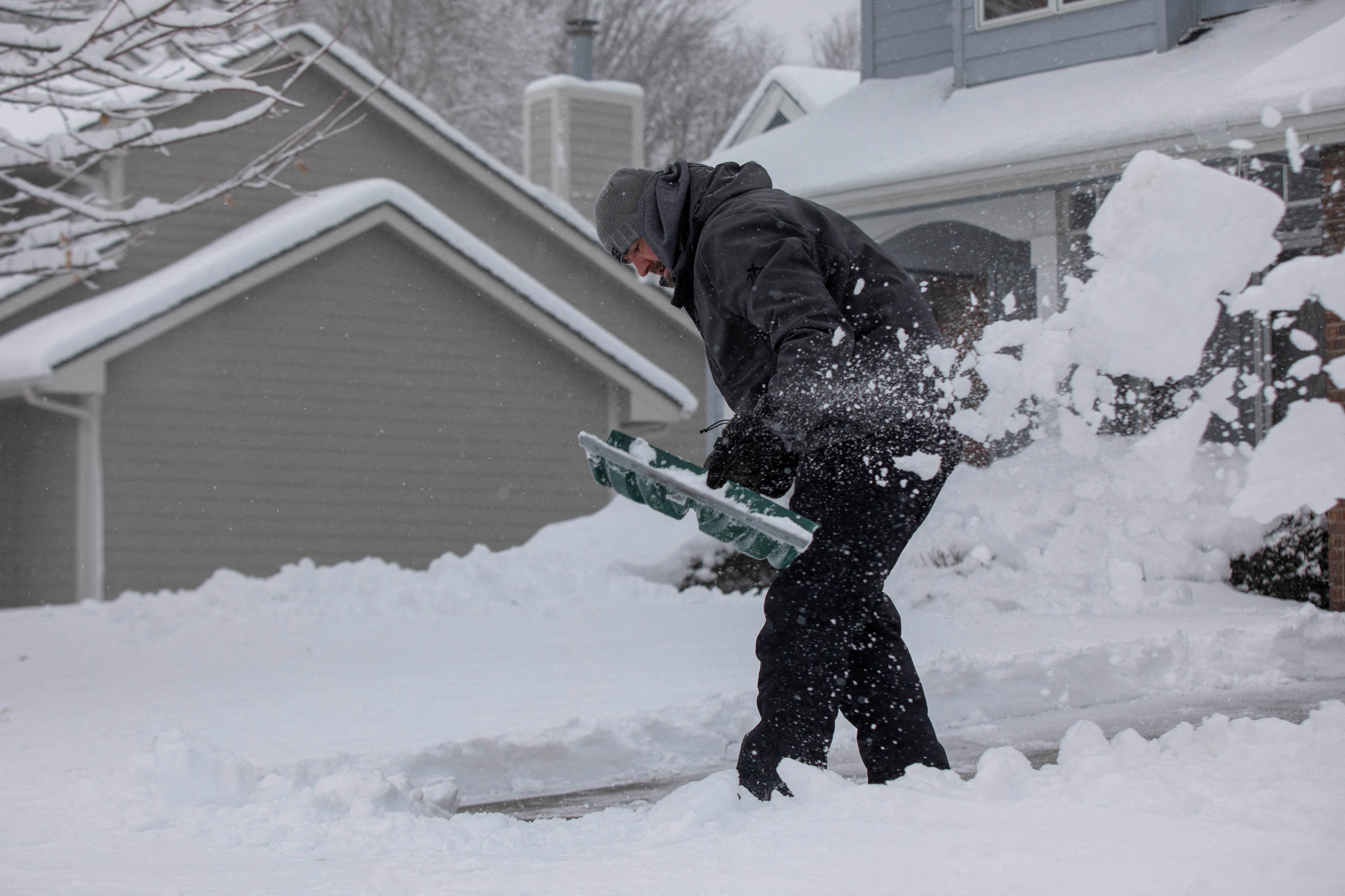 Zach Brobst shovels in his driveway after a snowstorm left several inches of snow in Clive, Iowa, U.S., January 9, 2024. 