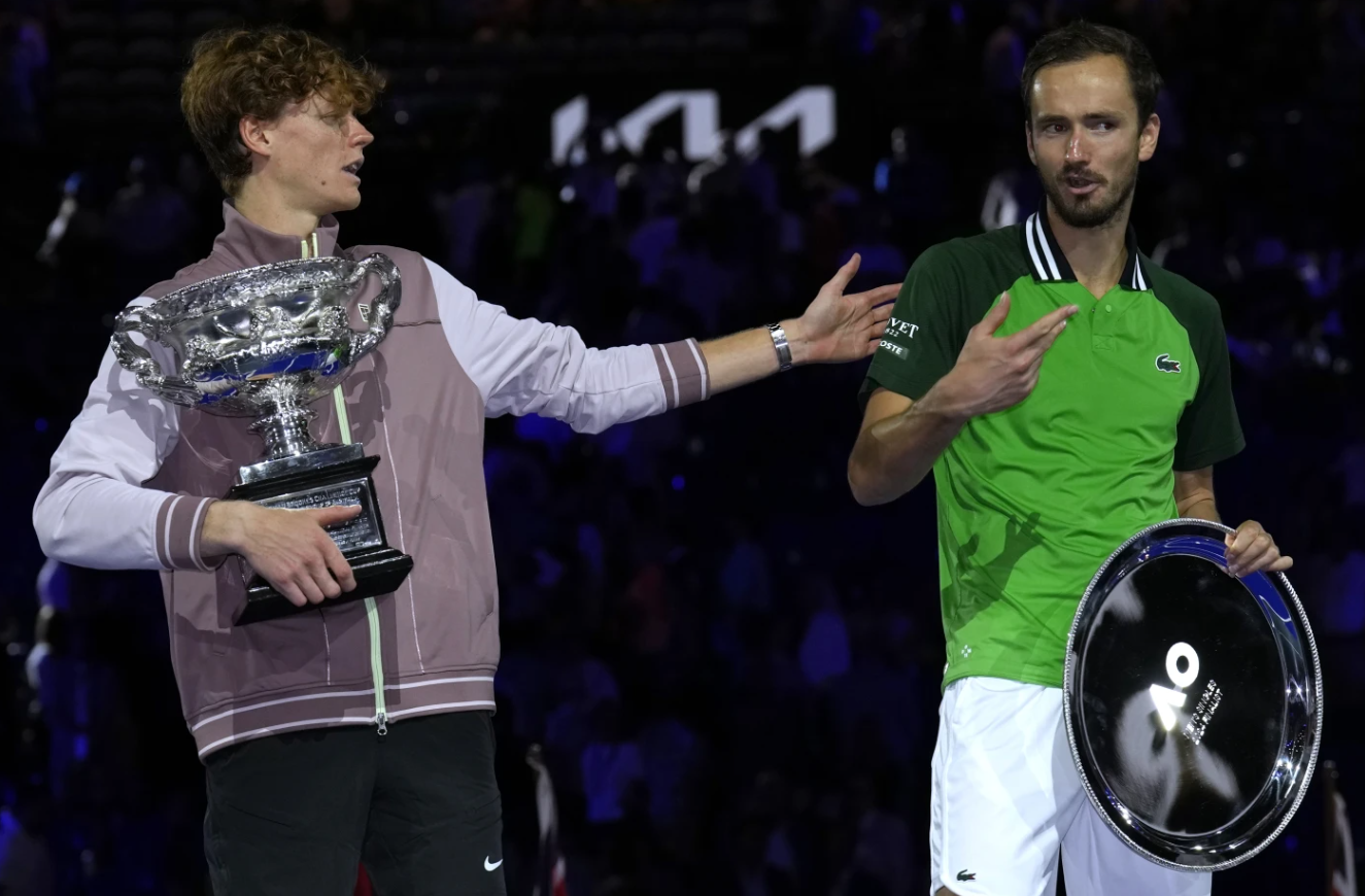 Jannik Sinner, left, of Italy gestures as he holds the Norman Brookes Challenge Cup after defeating Daniil Medvedev, right, of Russia in the men’s singles final of the Australian Open tennis championships at Melbourne Park in Melbourne, Australia, Sunday, Jan. 28, 2024.