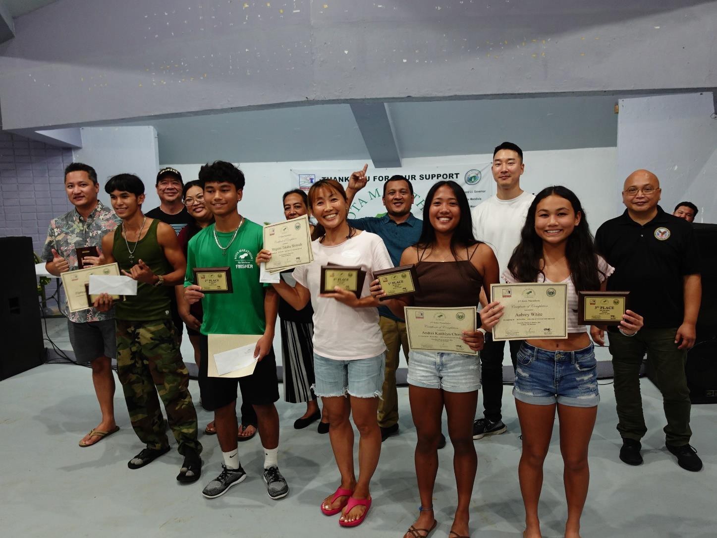 Top finishers in the 5K of Rota Marathon 2024 on Jan. 13, 2024 are recognized at the awards banquet in Songsong, Rota.  From left, Elphrain Taimanao Jr. (1st place) and Peter John White (2nd place) of the men’s division and Megumi Takaku Shimada (2nd place), Andrei Chavez (1st place), and Aubrey White (3rd place) of the women’s division. Not pictured is men’s 3rd place finisher Jun Shimada.