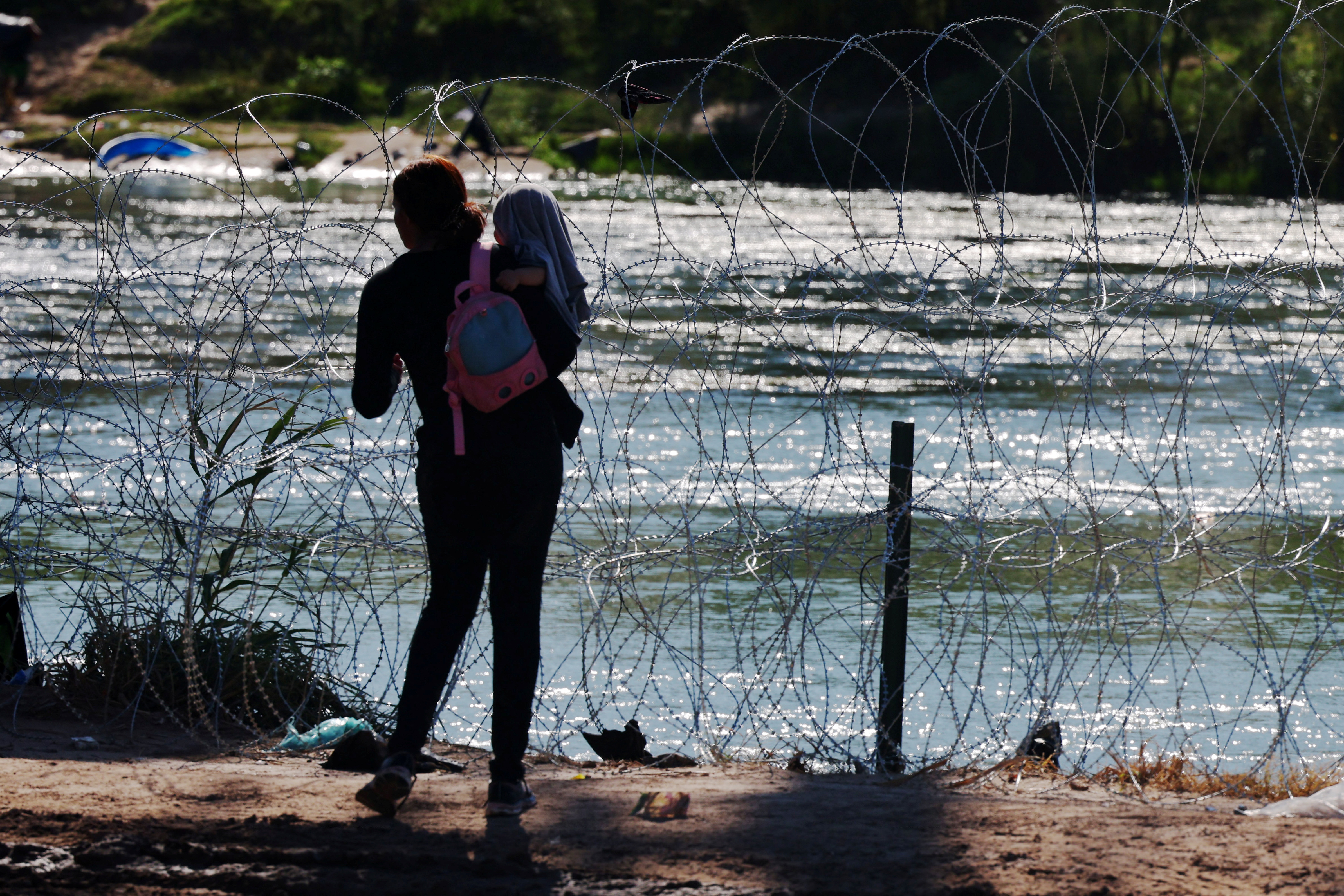 A migrant waits for others after crossing the Rio Grande and getting over the razor wire in Eagle Pass, Texas, U.S., September 29, 2023. 