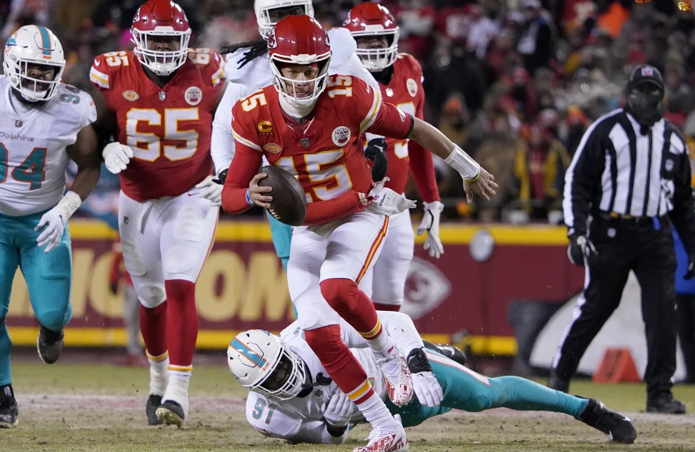 Kansas City Chiefs quarterback Patrick Mahomes (15) runs in front of Miami Dolphins defensive end Emmanuel Ogbah (91) during the first half of an NFL wild-card playoff football game Saturday, Jan. 13, 2024, in Kansas City, Mo.