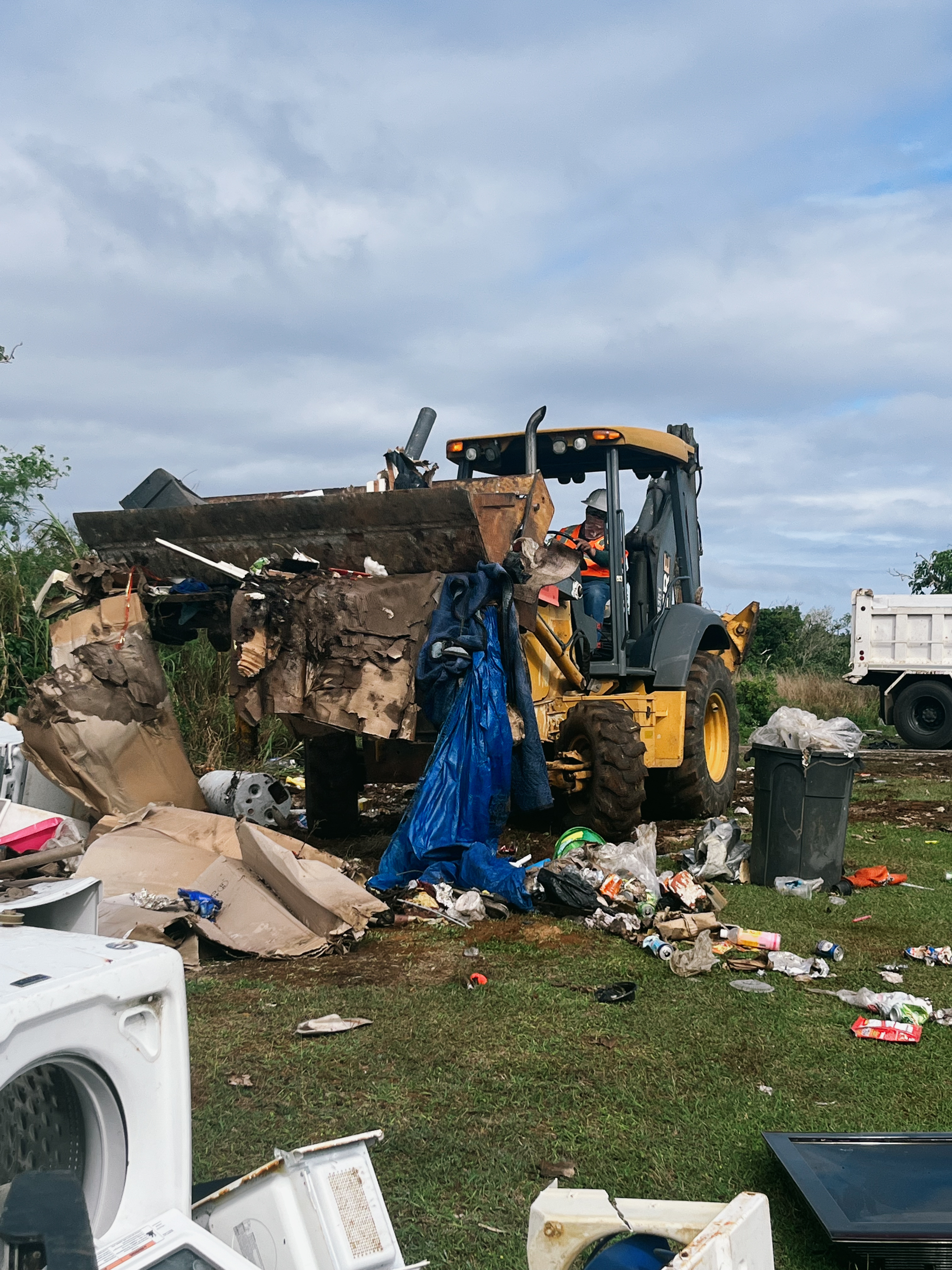 The Guam Department of Public Works Highway Maintenance crewmembers clear a recurring dump site along the entrance of Two Lover’s Point.
