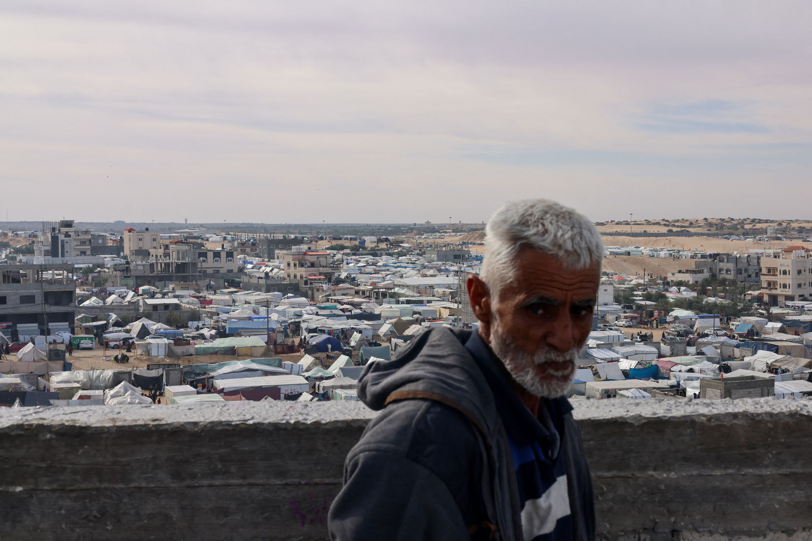 A man looks on near a tent camp where displaced Palestinians, who fled their houses due to Israeli strikes, take shelter, in Rafah in the southern Gaza Strip January 21, 2024. 