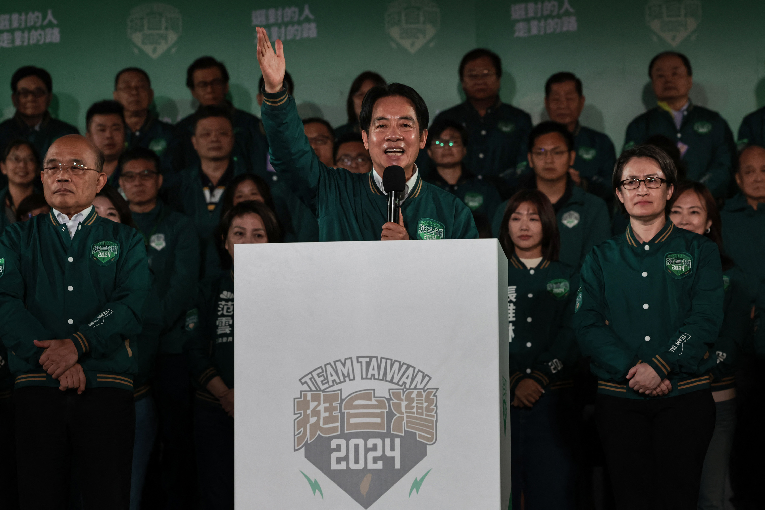 Taiwan's President-elect Lai Ching-te, middle, addresses supporters as he stands with his running mate, Hsiao Bi-khim, right, during a rally outside the headquarters of the Democratic Progressive Party in Taipei on Saturday, Jan. 13, 2024, after Lai won the presidential election. 
