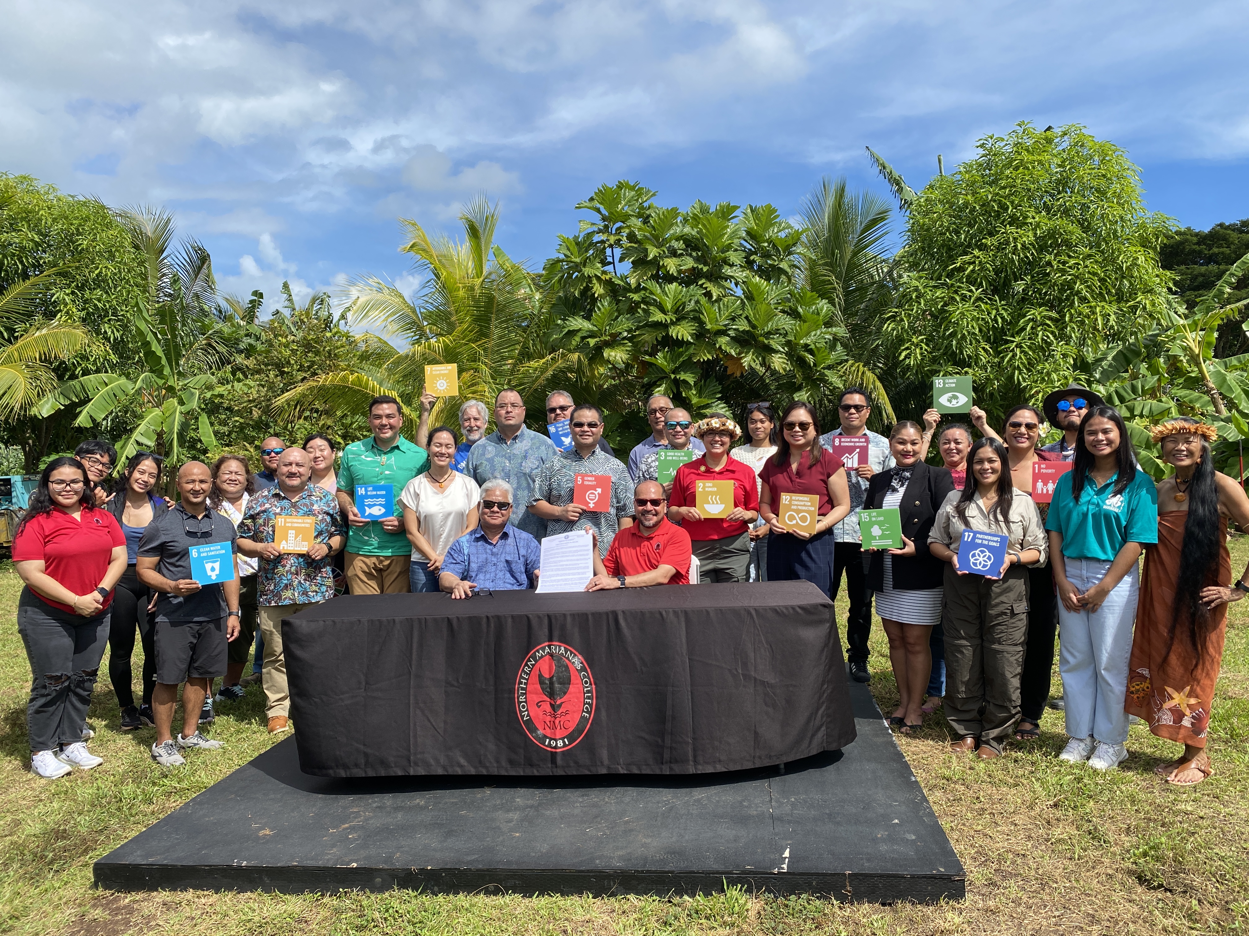 Gov. Arnold I. Palacios, left seated, and Northern Marianas College President Galvin Deleon Guerrero, right, hold a copy of an executive order committing the CNMI to the Green Growth Initiative at NMC’s Agriculture Research Station on Friday, Jan. 26. Also in photo are community stakeholders and other CNMI government officials. 