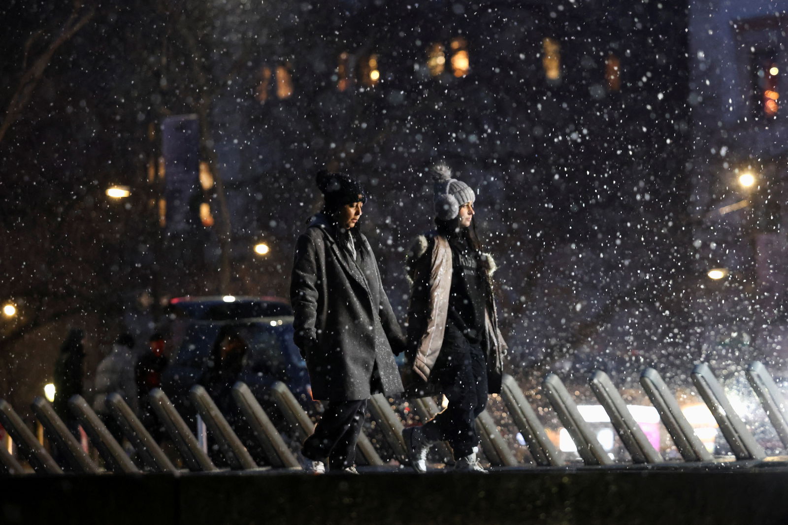 People walk as snow falls in New York City, U.S., January 6, 2024. 