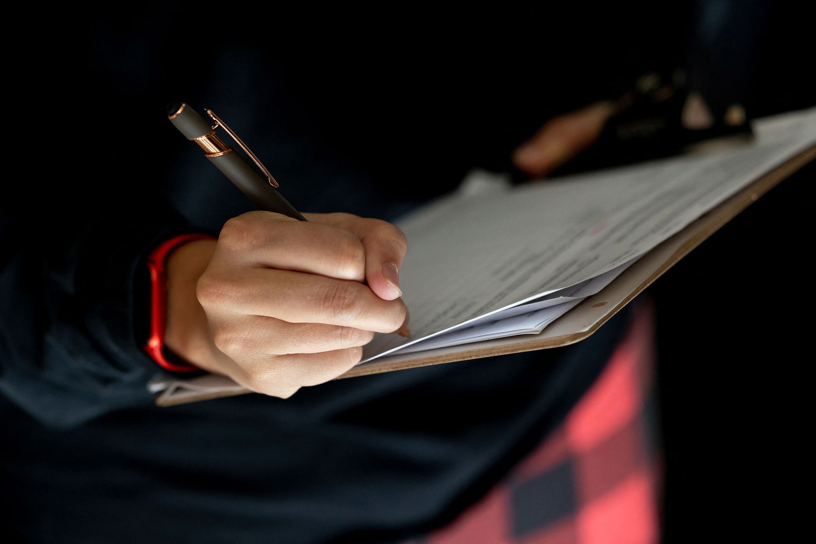 A voter, who did not wish to be identified, signs a petition at her home after speaking with canvassers from No Labels, a third-party political group that is gathering support ahead of next year's U.S. presidential election, in Cheyenne, Wyoming, U.S., December 16, 2023. 