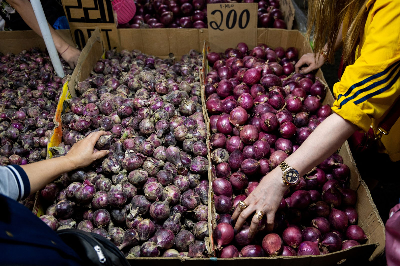 People buy onions displayed at a stall in a public market in Manila, the Philippines, January 28, 2023. 