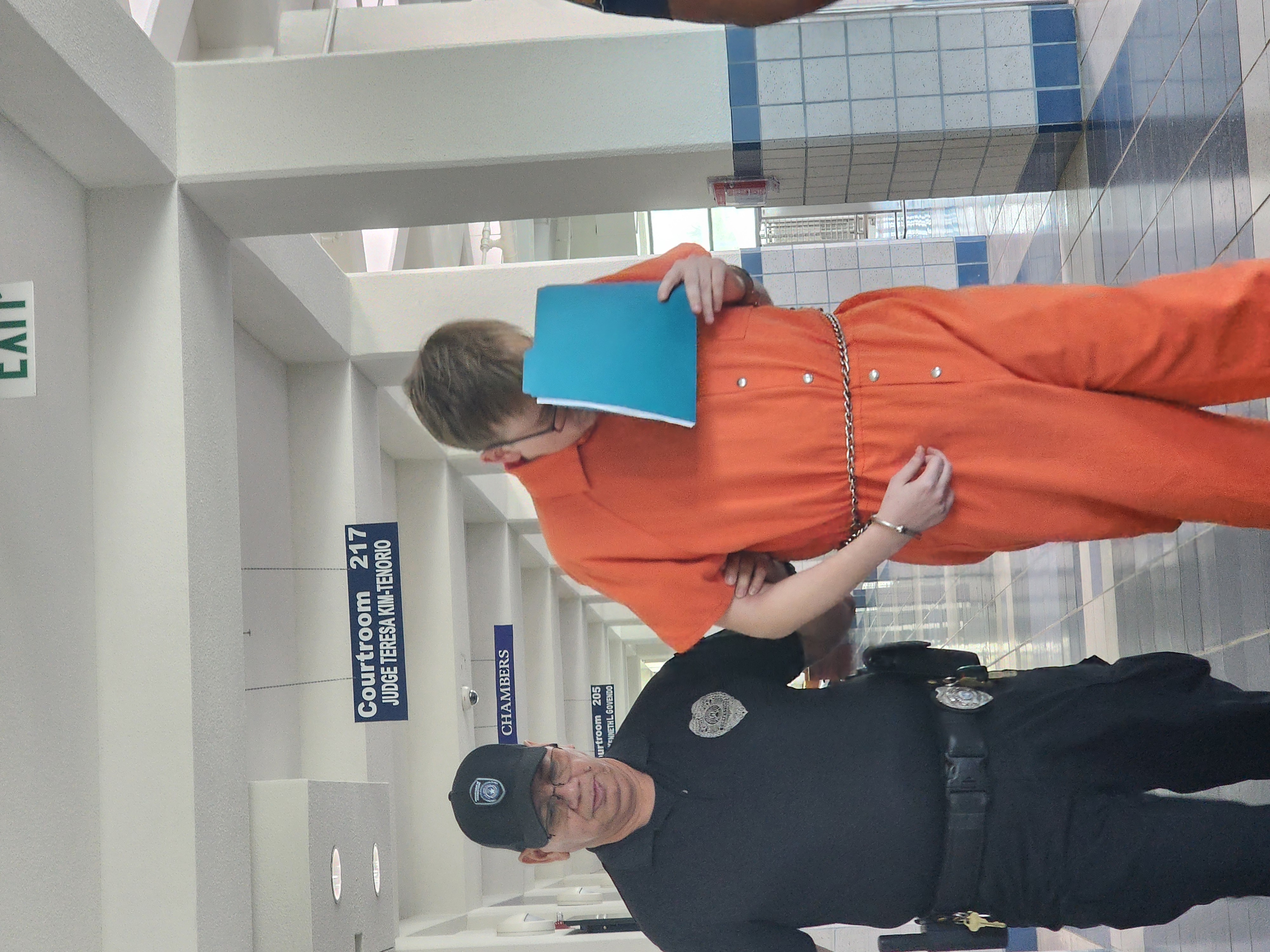 Charles Lee Dewey III — also known as Carter Allen Widmor —covers his face as he is escorted by a Corrections officer at the CNMI courthouse on Monday.