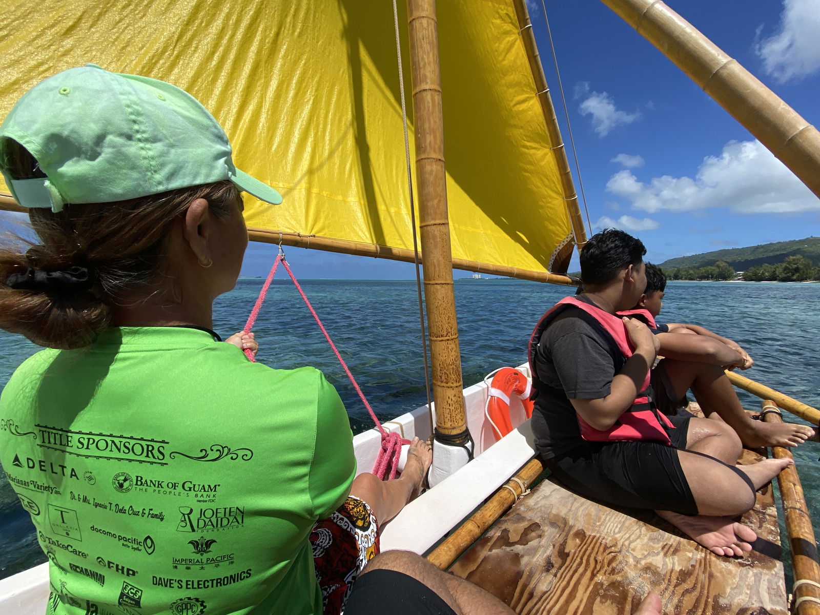500 Sails Program Manager Andrea Carr, left, accompanies two lifejacket-clad passengers on a traditional canoe in the Saipan lagoon. Free canoe rides are available this month at Crowne Plaza Resort.