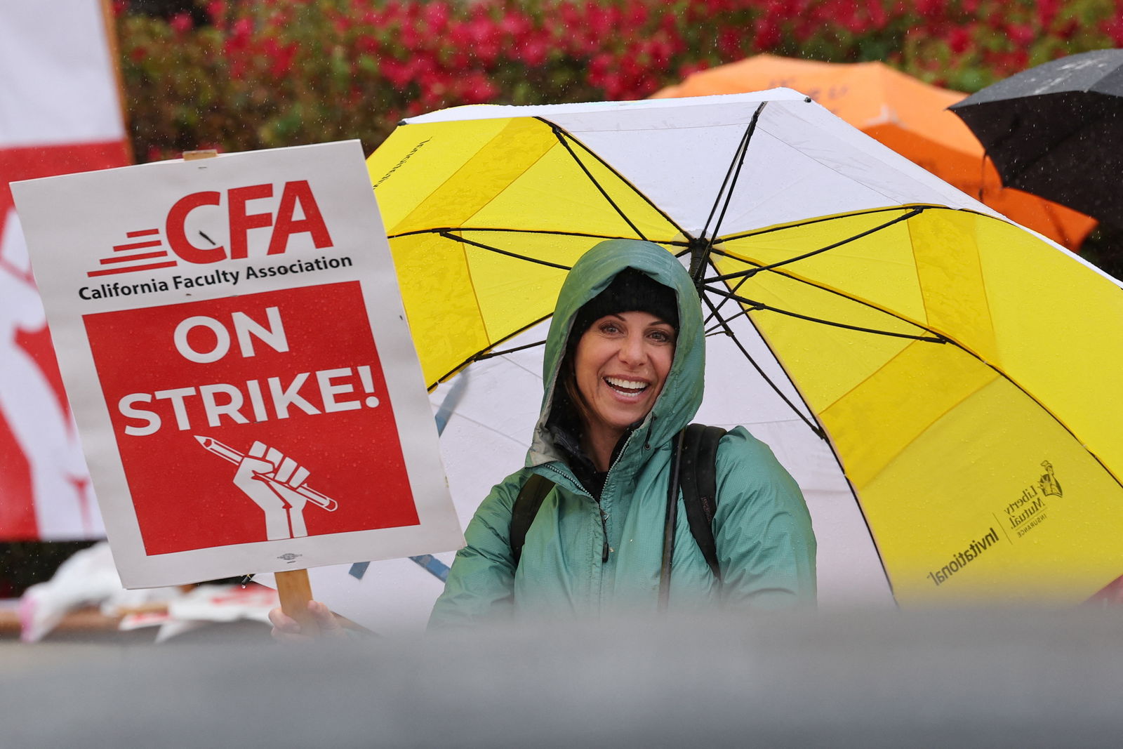 A person holds an umbrella while picketing begins at San Diego State University, as the California Faculty Association, the union representing 29,000 professors, lecturers, librarians, counselors and coaches across the California State University start a planned five-day strike in San Diego, California, U.S. January 22, 2024. 