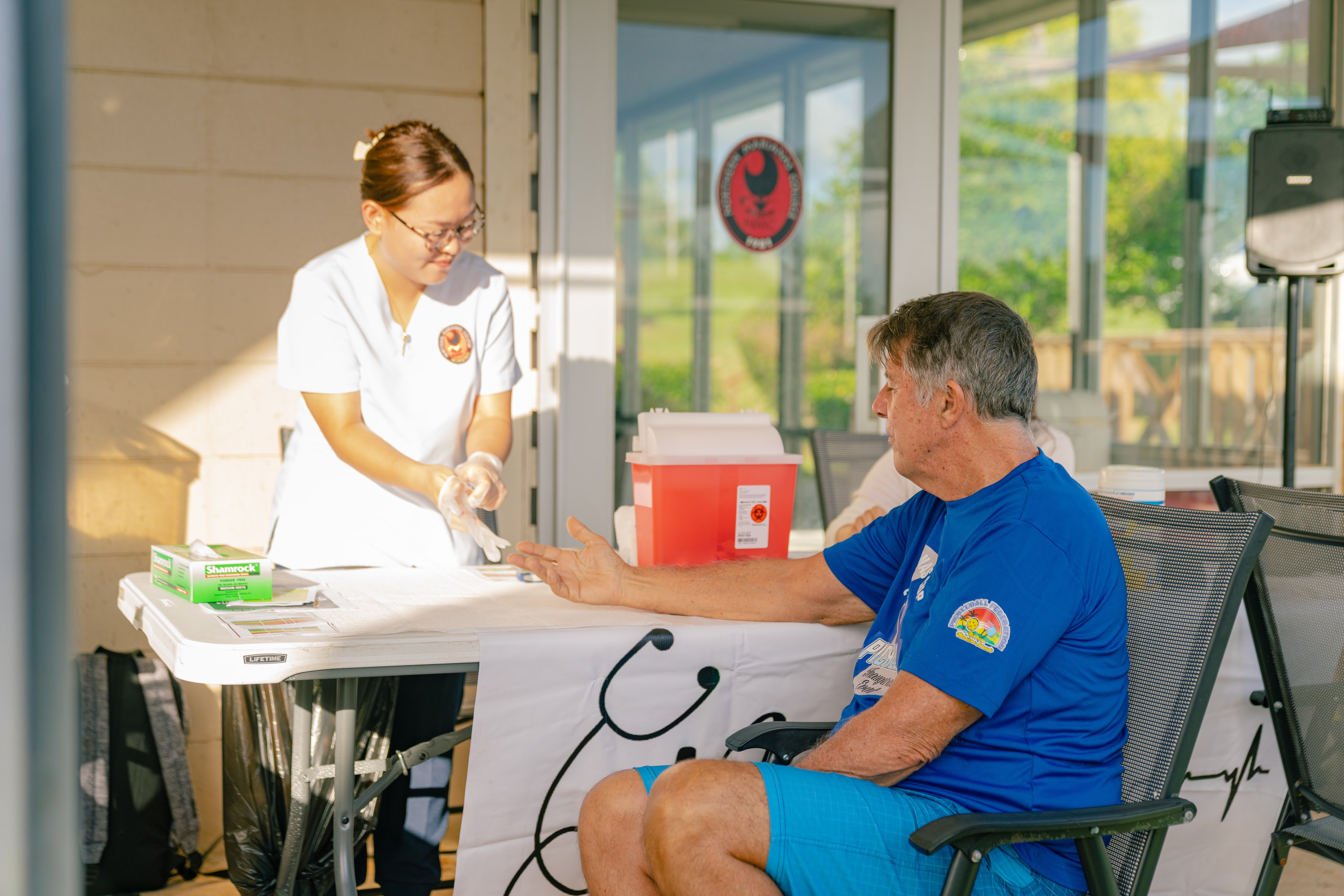 A Northern Marianas College nursing student checks the blood sugar of a participant at NMC's Health Night in 2023.