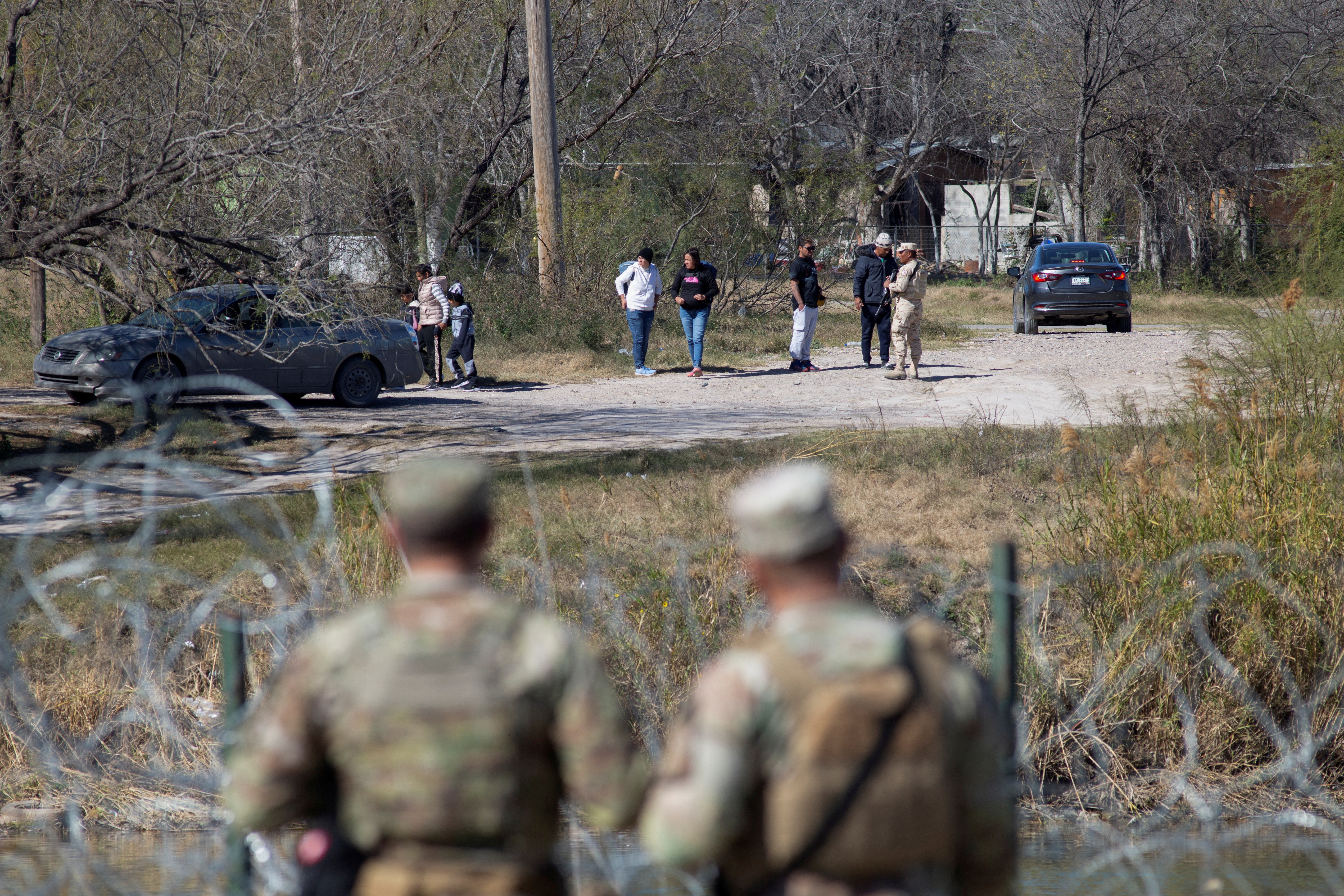 Texas National Guard troops watch a Mexican official prevent a group of people from entering the Rio Grande River across from Shelby Park at the U.S.-Mexico border in Eagle Pass, Texas, U.S., January 12, 2024. 