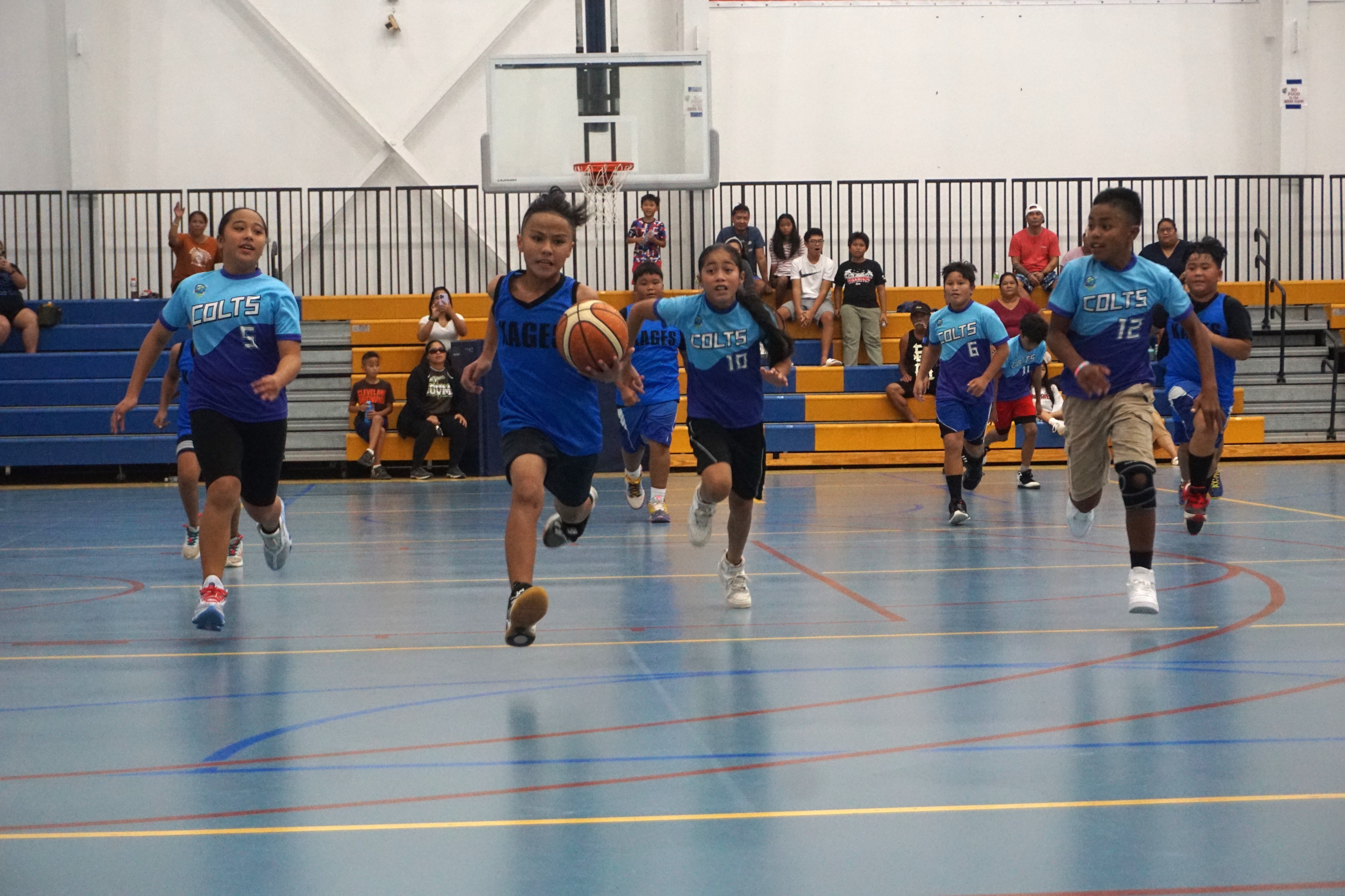 KAG 1's Benaiah Murphy dribbles for the fast break finish as TIN 1 defenders chase after him during the co-ed elementary school division title game of the IT&E Interscholastic Basketball League SY23-24 at the Marianas High School gym on Saturday.