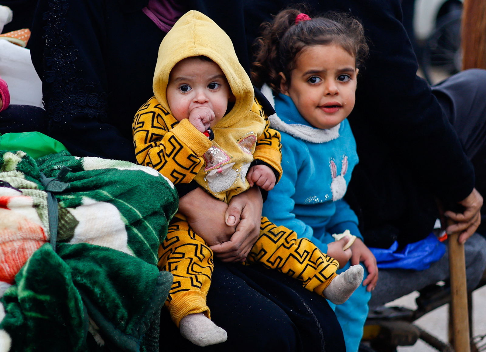Children rest as Palestinians fleeing Khan Younis, due to the Israeli ground operation, move towards Rafah, amid the ongoing conflict between Israel and the Palestinian Islamist group Hamas, in the southern Gaza Strip, January 27, 2024. 