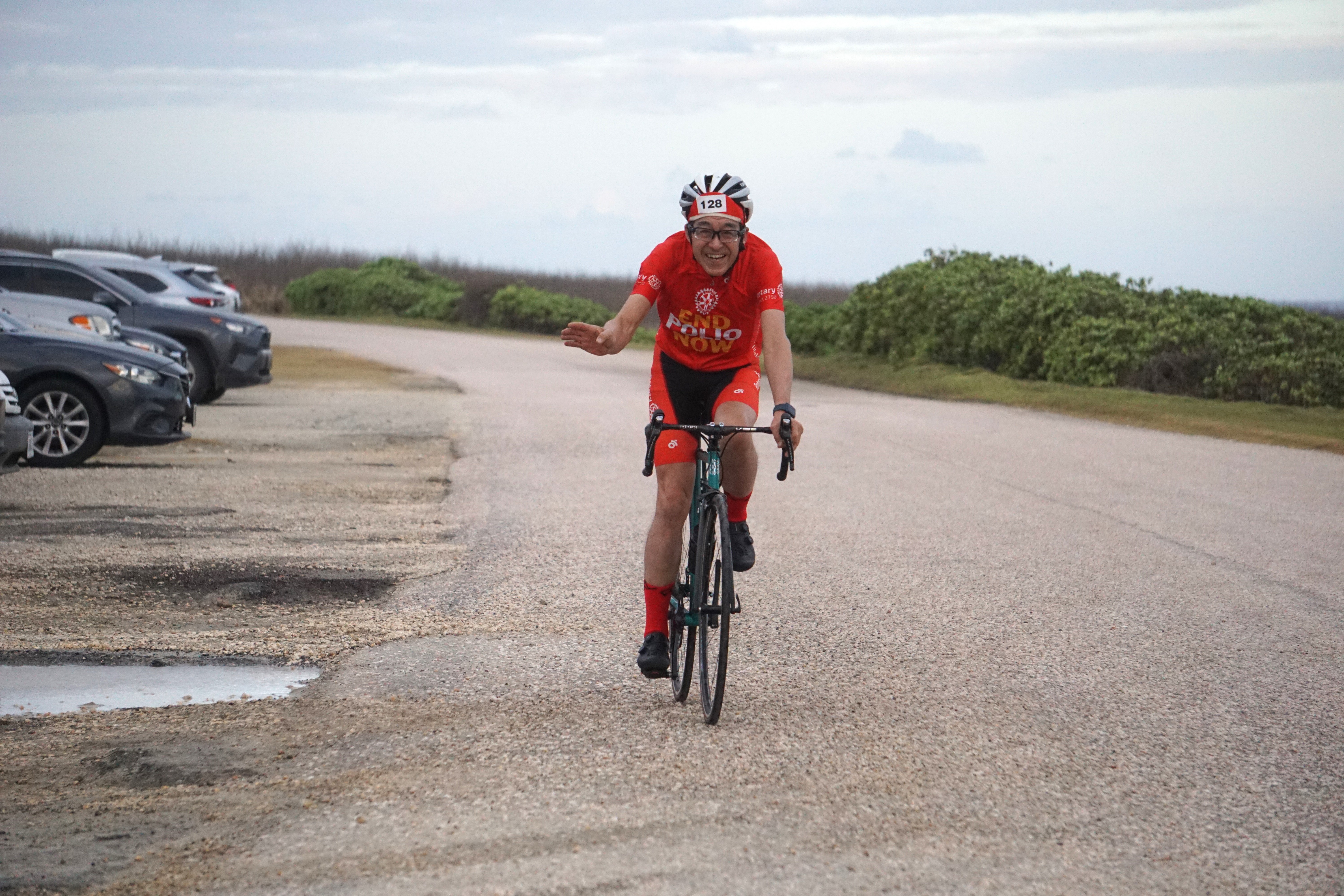 Rotary Club International District 2750 Governor Yoichiro Miyazaki waves as he completes the short course of the 2024 Rotary Club of Saipan "End Polio Now" Cycling Challenge at Banzai Cliff on Saturday.