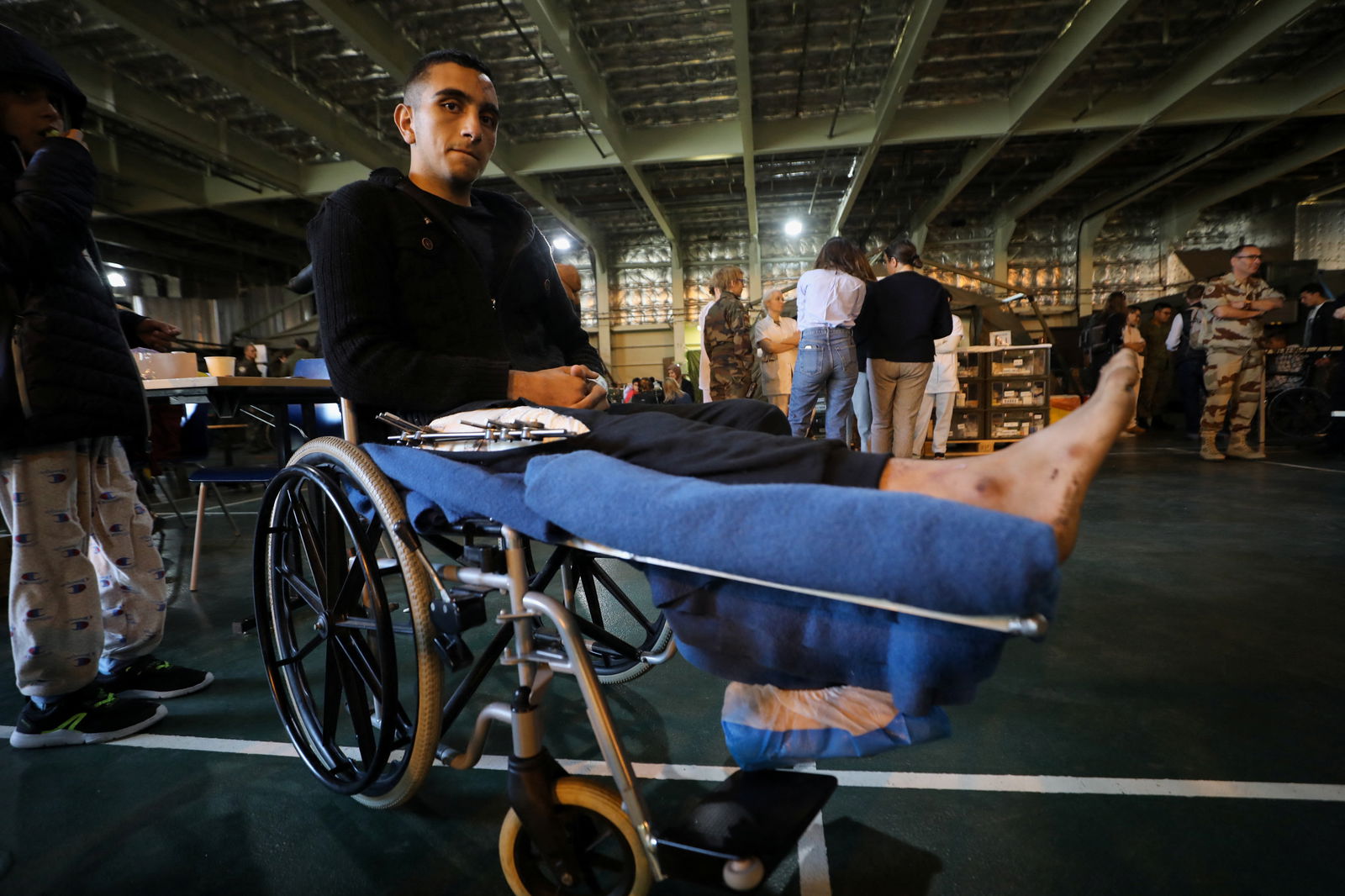 Abdul Rahman Abu Hamda, a wounded Palestinian in a wheelchair looks on in the hospital onboard the French ship amphibious helicopter carrier Dixmude as it docks, amid the ongoing conflict between Israel and the Palestinian Islamist group Hamas, in the city of Al-Arish, Sinai peninsula, Egypt, January 21, 2024. 