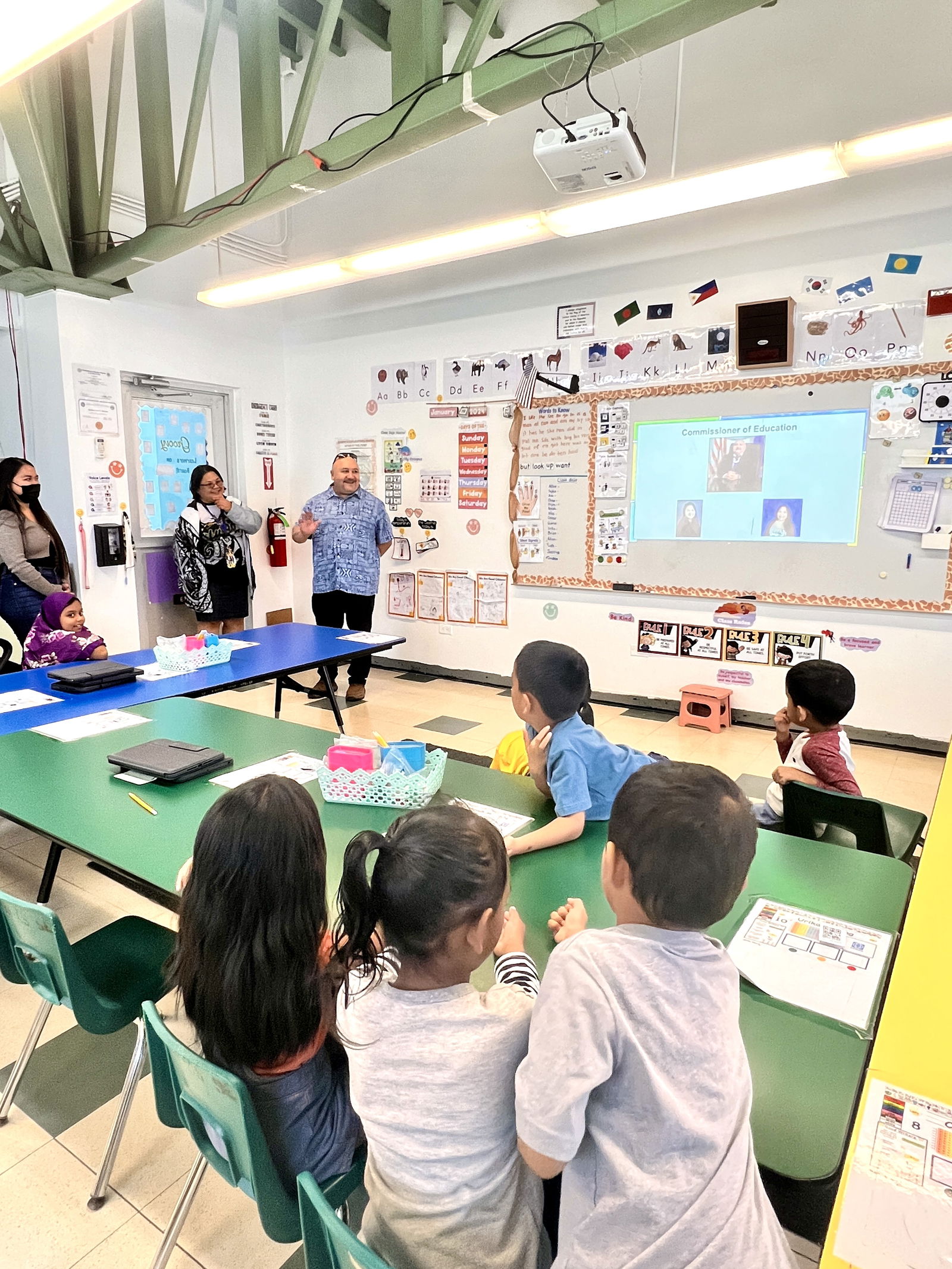 Dr. Lawrence Camacho, the newly named commissioner of education, greets the kindergarten students of Sinapalo Elementary School.