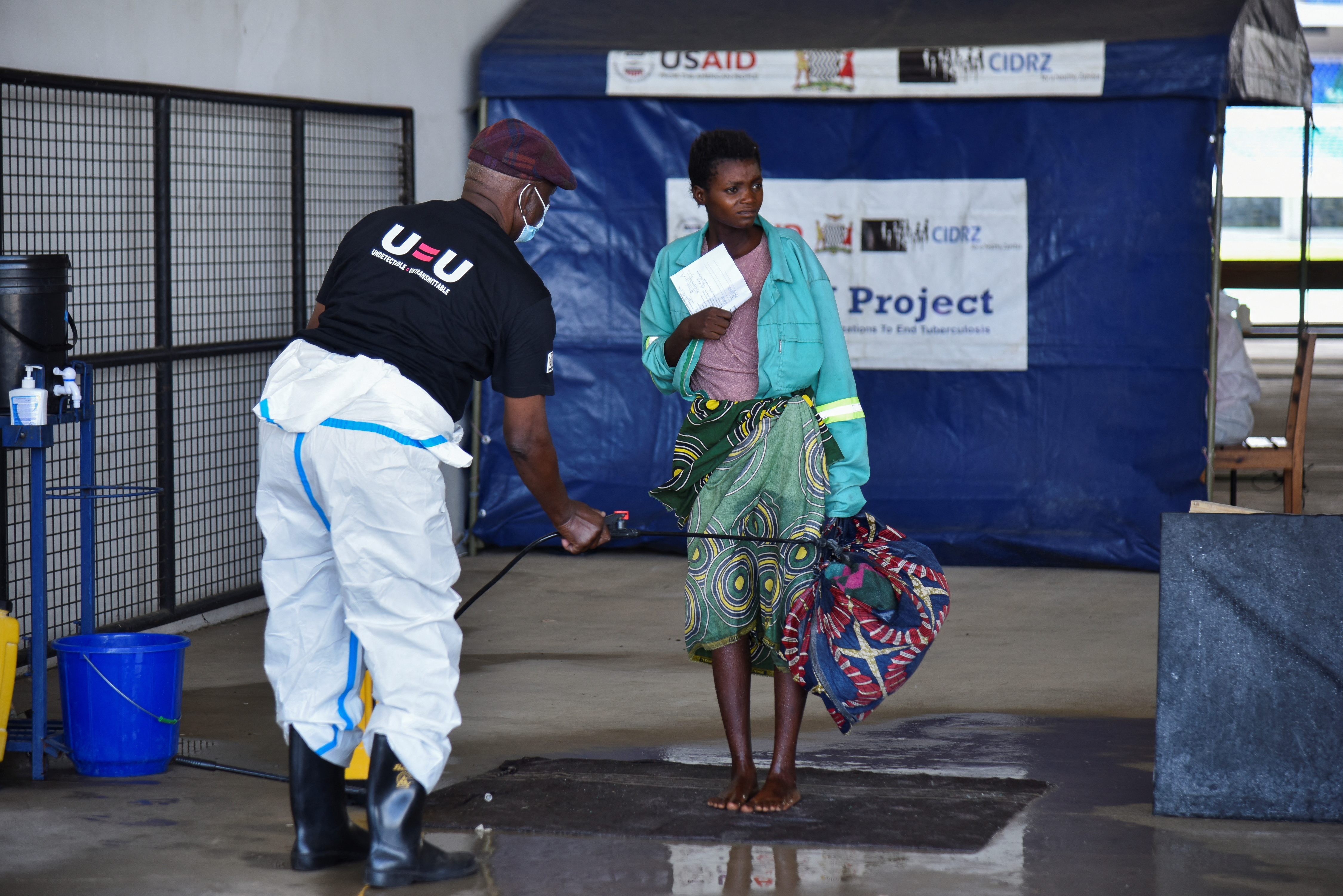 A woman is disinfected as she arrives at a temporary cholera treatment centre which has been set up to deal with the latest deadly cholera outbreak at the Heroes National Stadium in Lusaka, Zambia January 17, 2024 