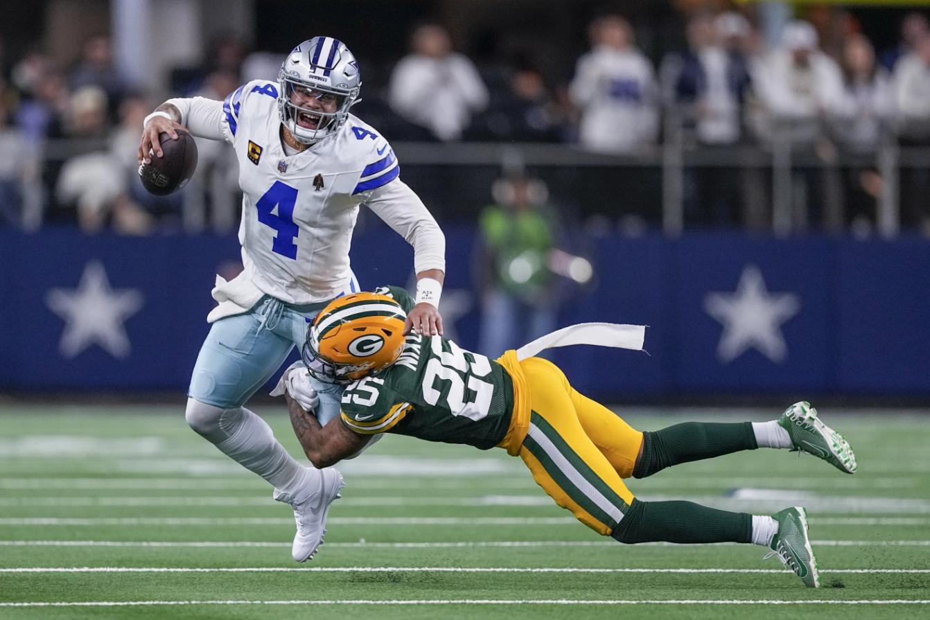 Dallas Cowboys quarterback Dak Prescott is brought down by Green Bay Packers cornerback Keisean Nixon during the first half of an NFL game, Sunday, Jan. 14, 2024 in Arlington, Texas.