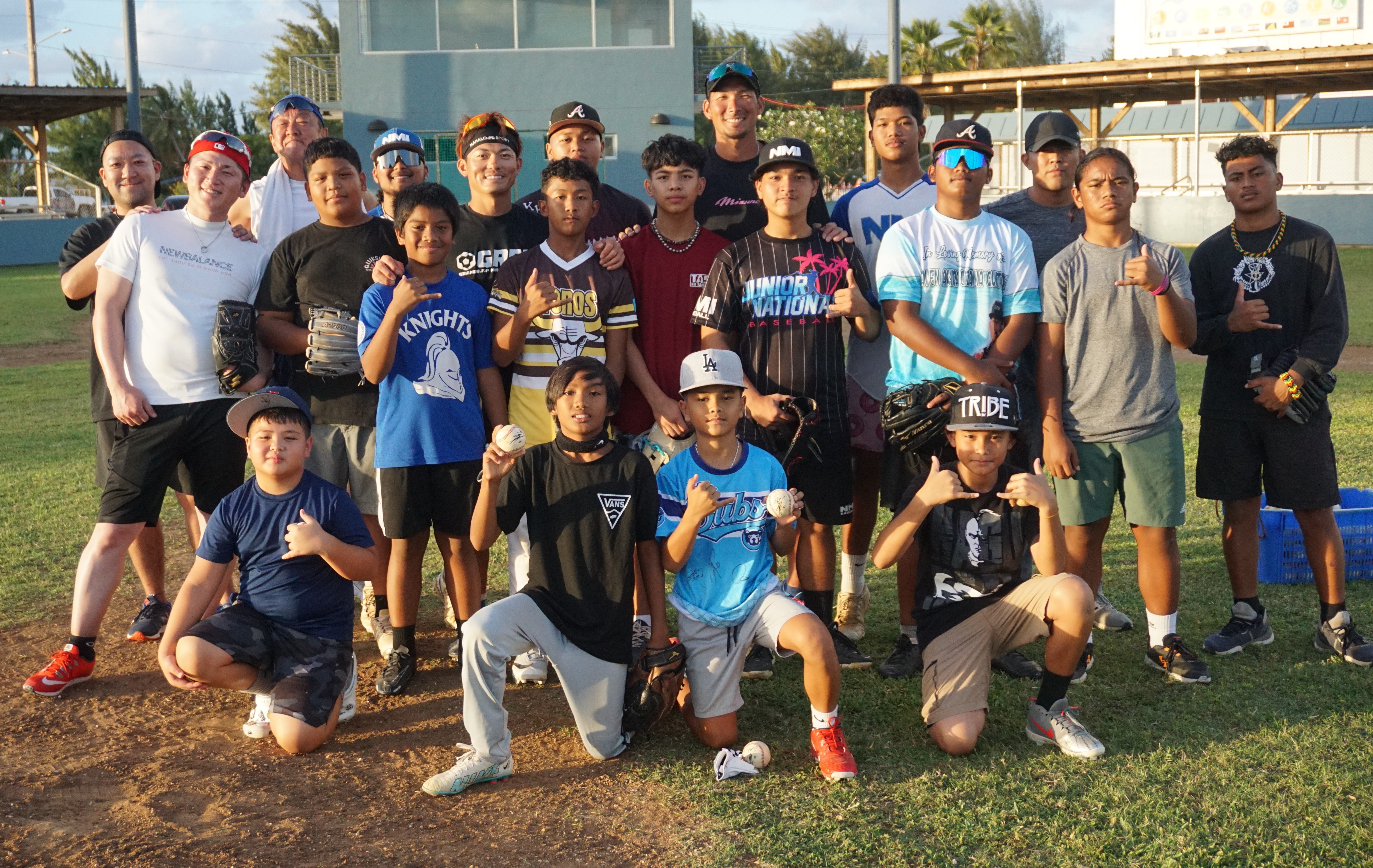 Young local residents pose with Nippon Professional Baseball players Taishi Ohta and Takuma Hayashi of the Yokohama DeNA Baystars after completing an hour-long baseball clinic at the Francisco “Tan Ko” Palacios Baseball Field on Saturday. 