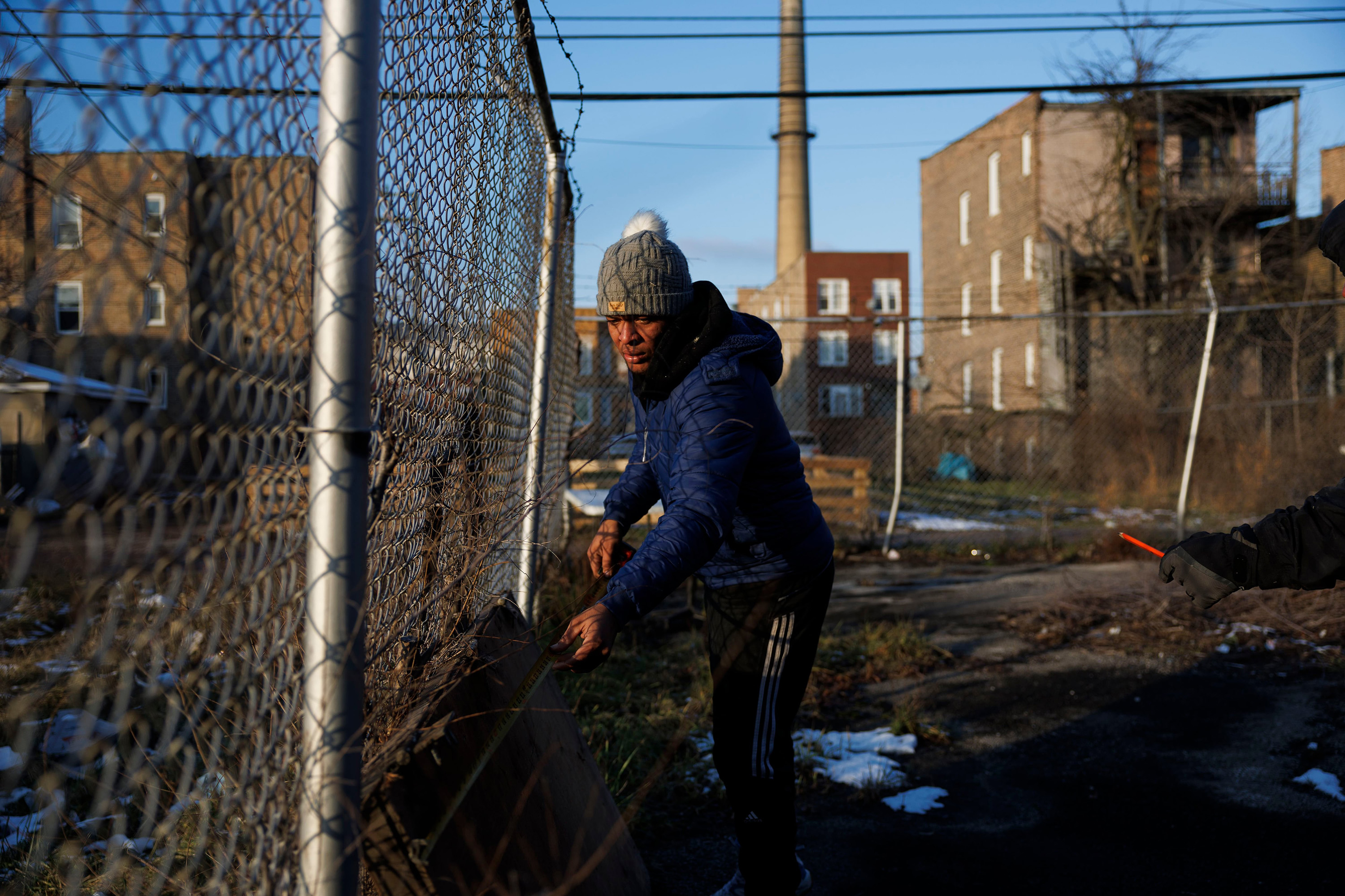 Rayni Cuadrado, 29, from Venezuela, measures a broken door behind the New Promise Land Missionary Baptist Church, Jan. 11, 2024, in Chicago. (Armando L. Sanchez/Chicago Tribune/TNS)