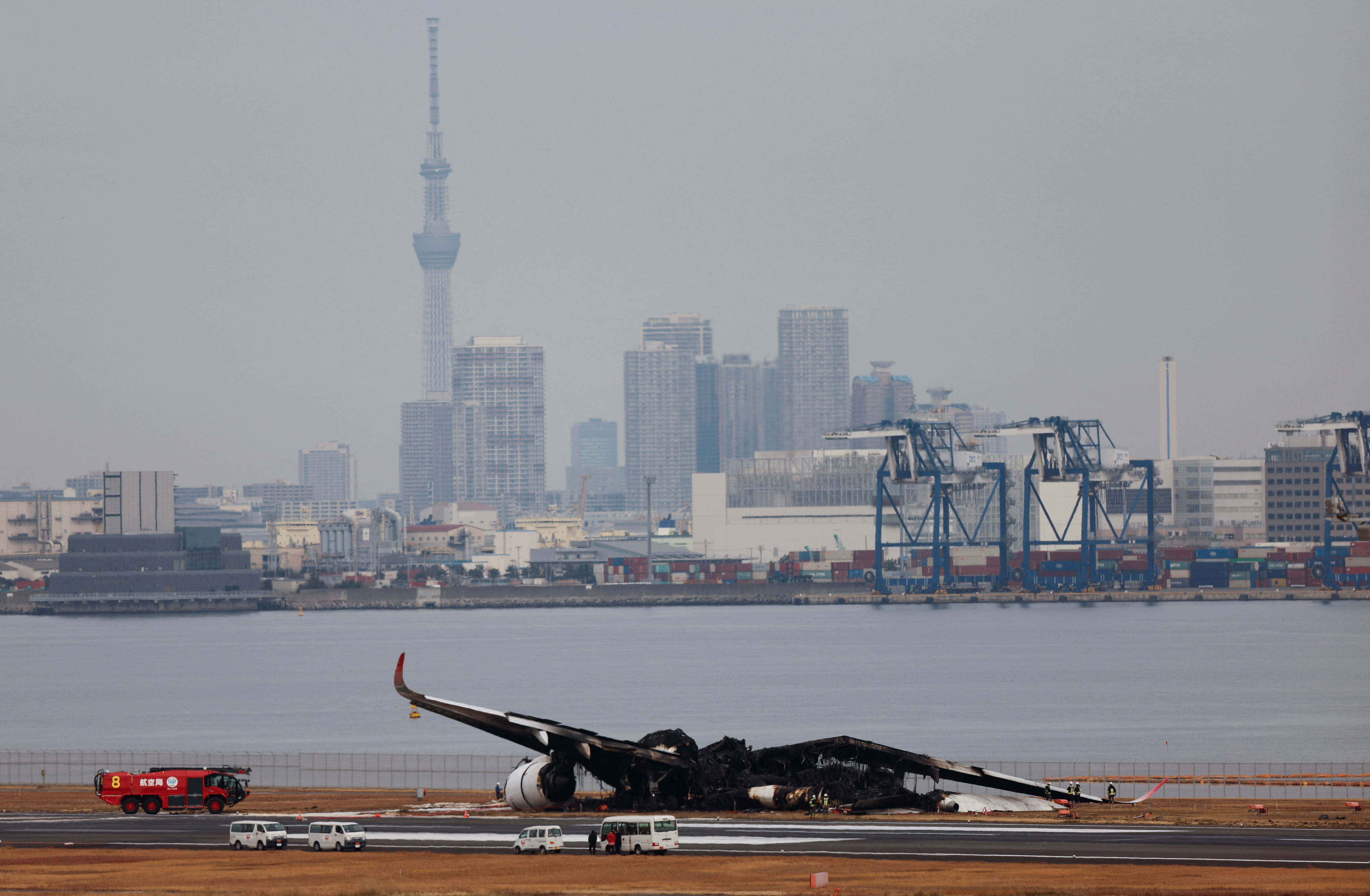 Officials investigate a burnt Japan Airlines (JAL) Airbus A350 plane after a collision with a Japan Coast Guard aircraft at Haneda International Airport in Tokyo, Japan January 3, 2024. 