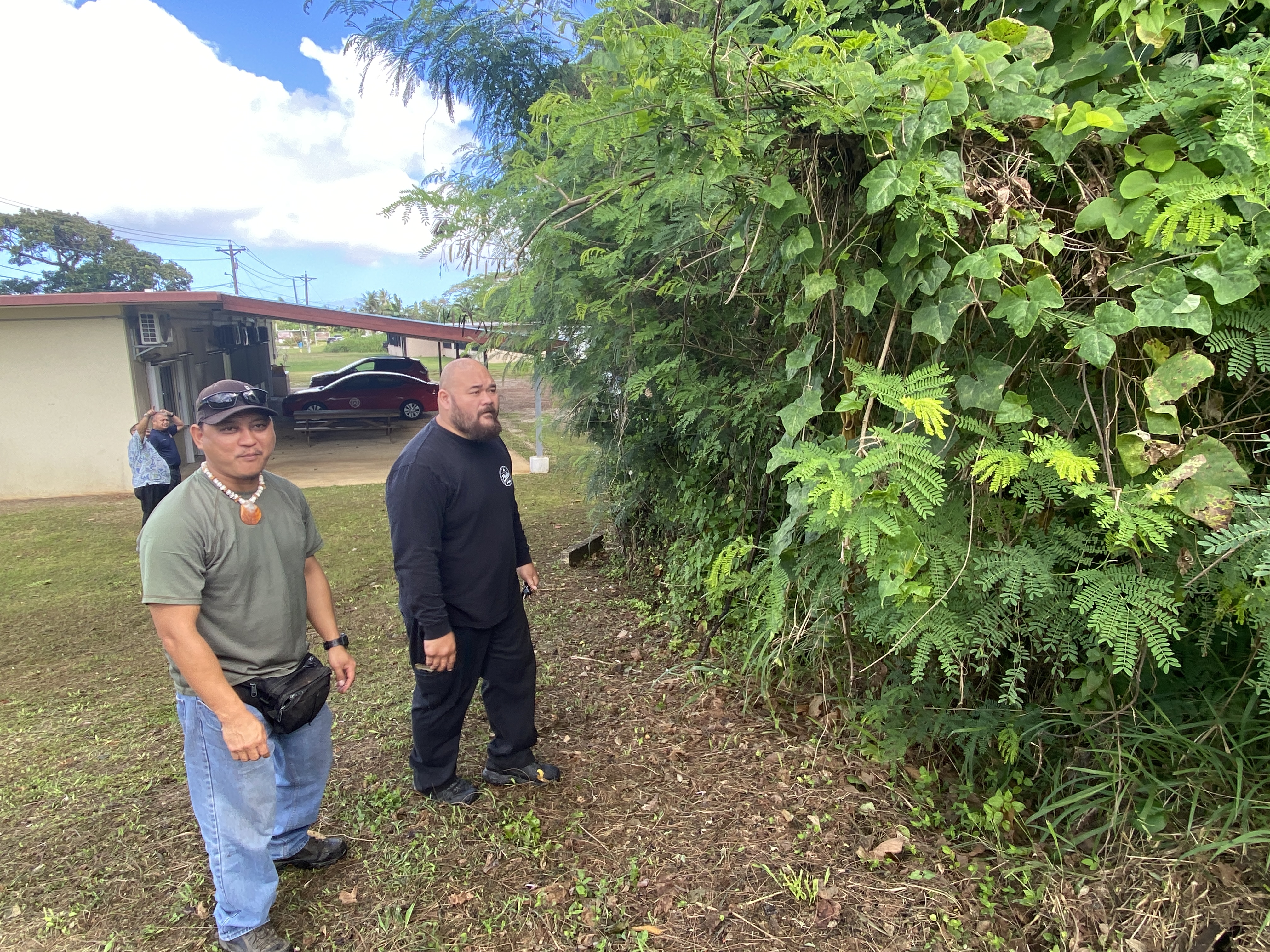 Invasive Species Technicians Jesse Deleon Guerrero and Andrew Lizama show Variety a velvet bean plant near their office.