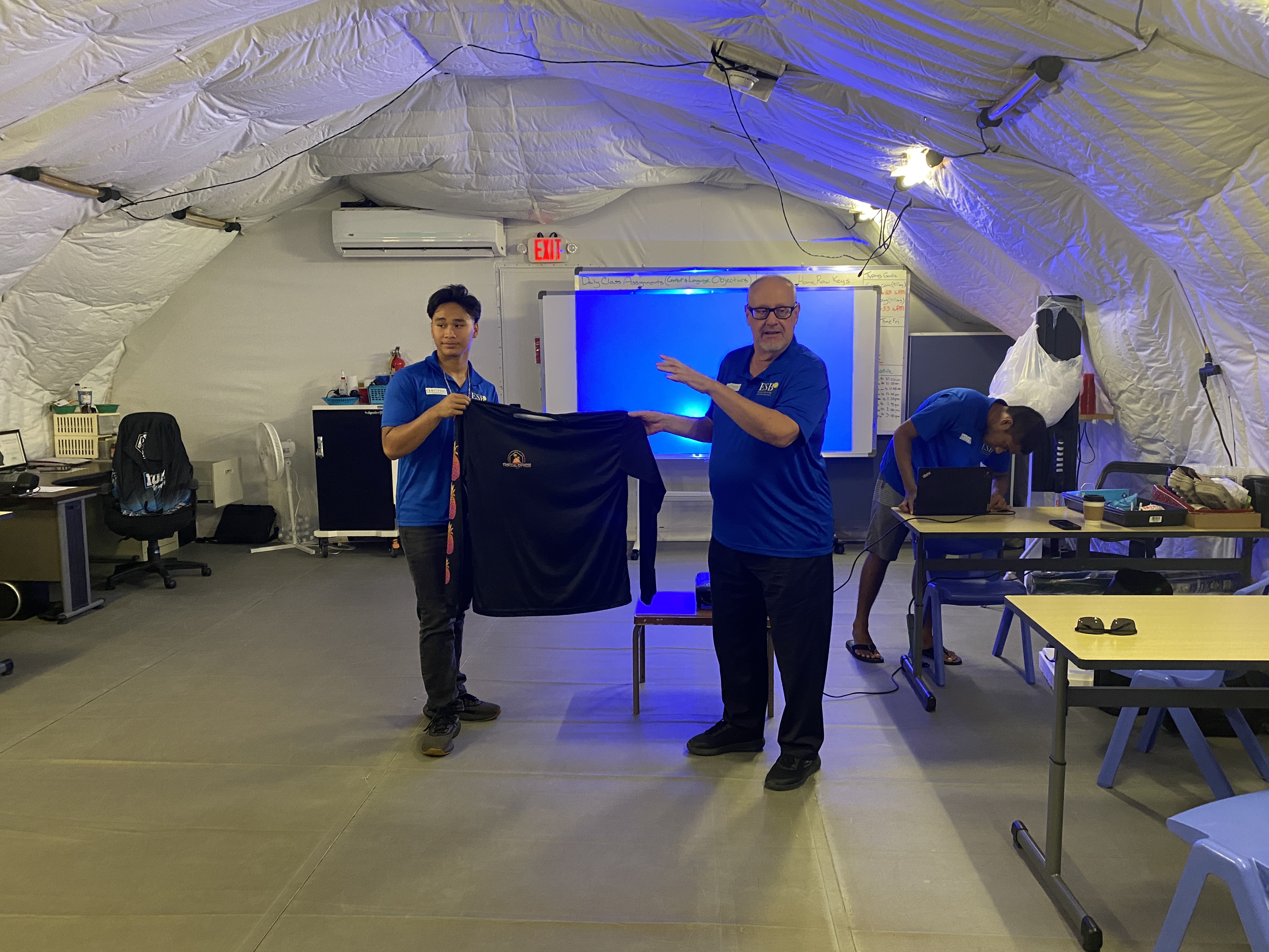 Jose Olopai, left, and Jim Arenovski show the front portion of the t-shirt created, marketed, advertised, and sold by the participants of the course.