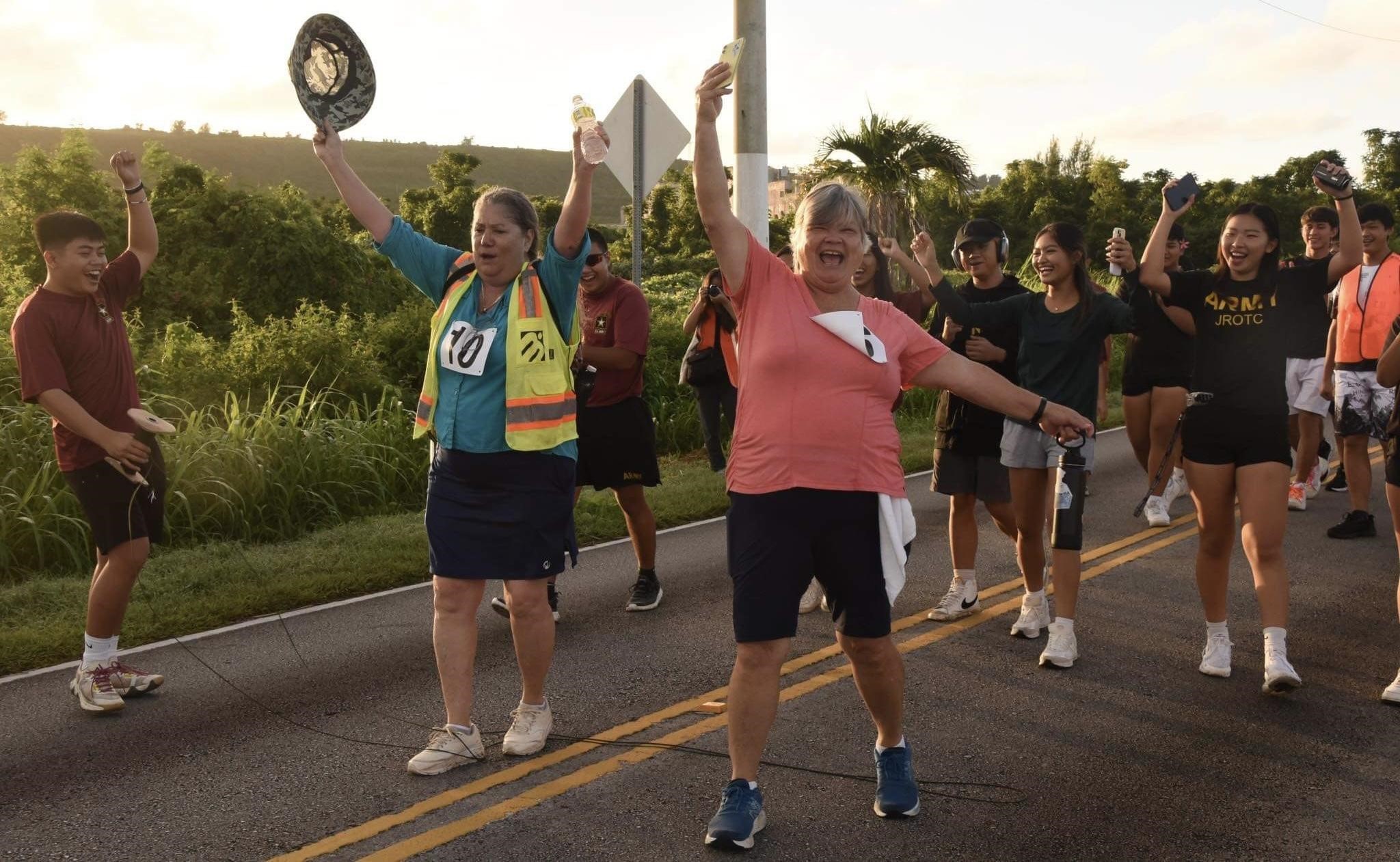 The Stallion Battalion cheers on two community members as they finish the run.