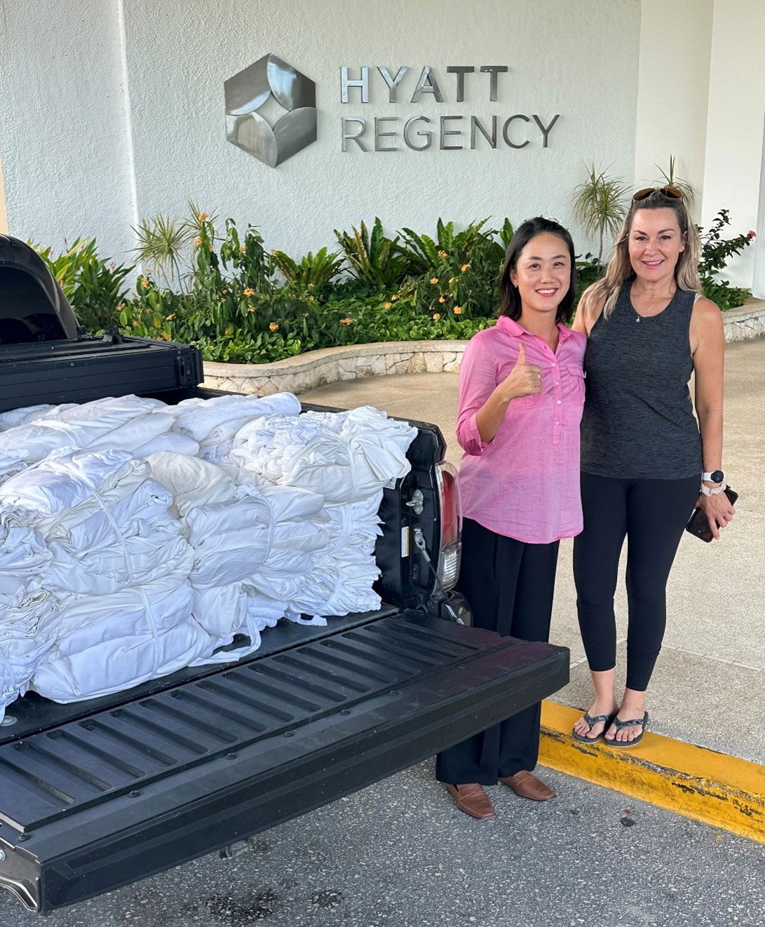 Sandy Staffler Weaver of the Saipan Humane Society, right, receives from Ally Hong, rooms director of Hyatt Regency Saipan, a donation of linens, one of the many items that SHS needs.