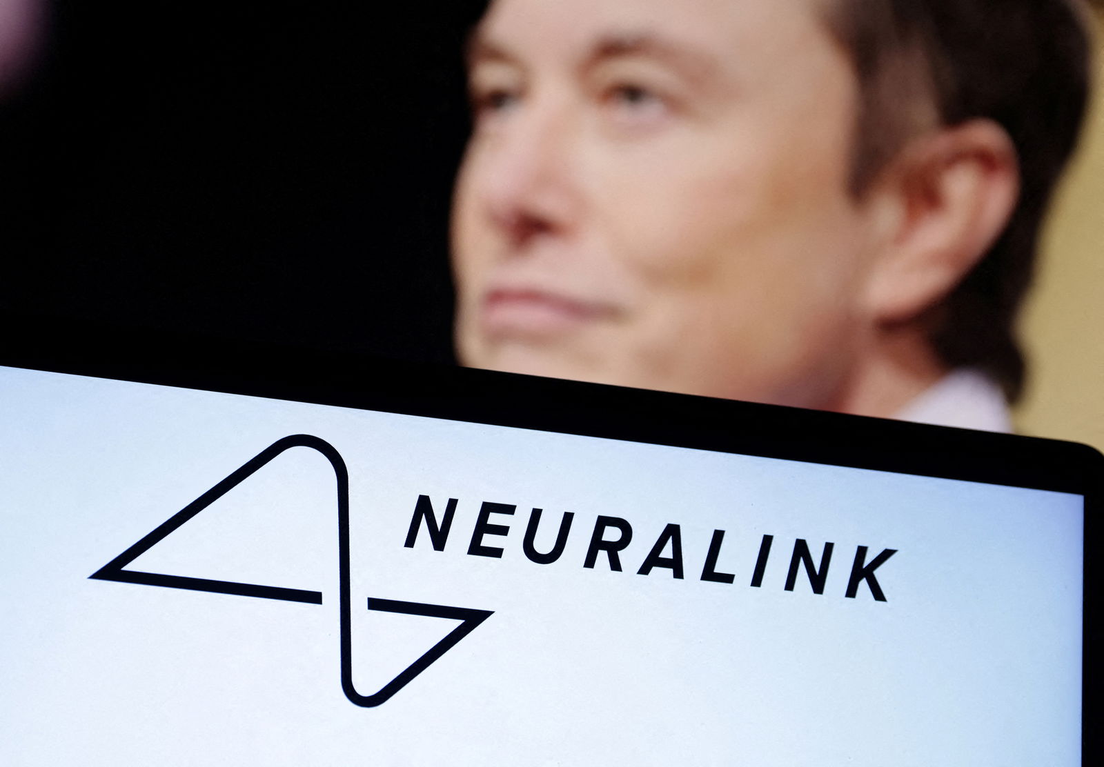 Neuralink logo and Elon Musk photo are seen in this illustration taken, December 19, 2022. 