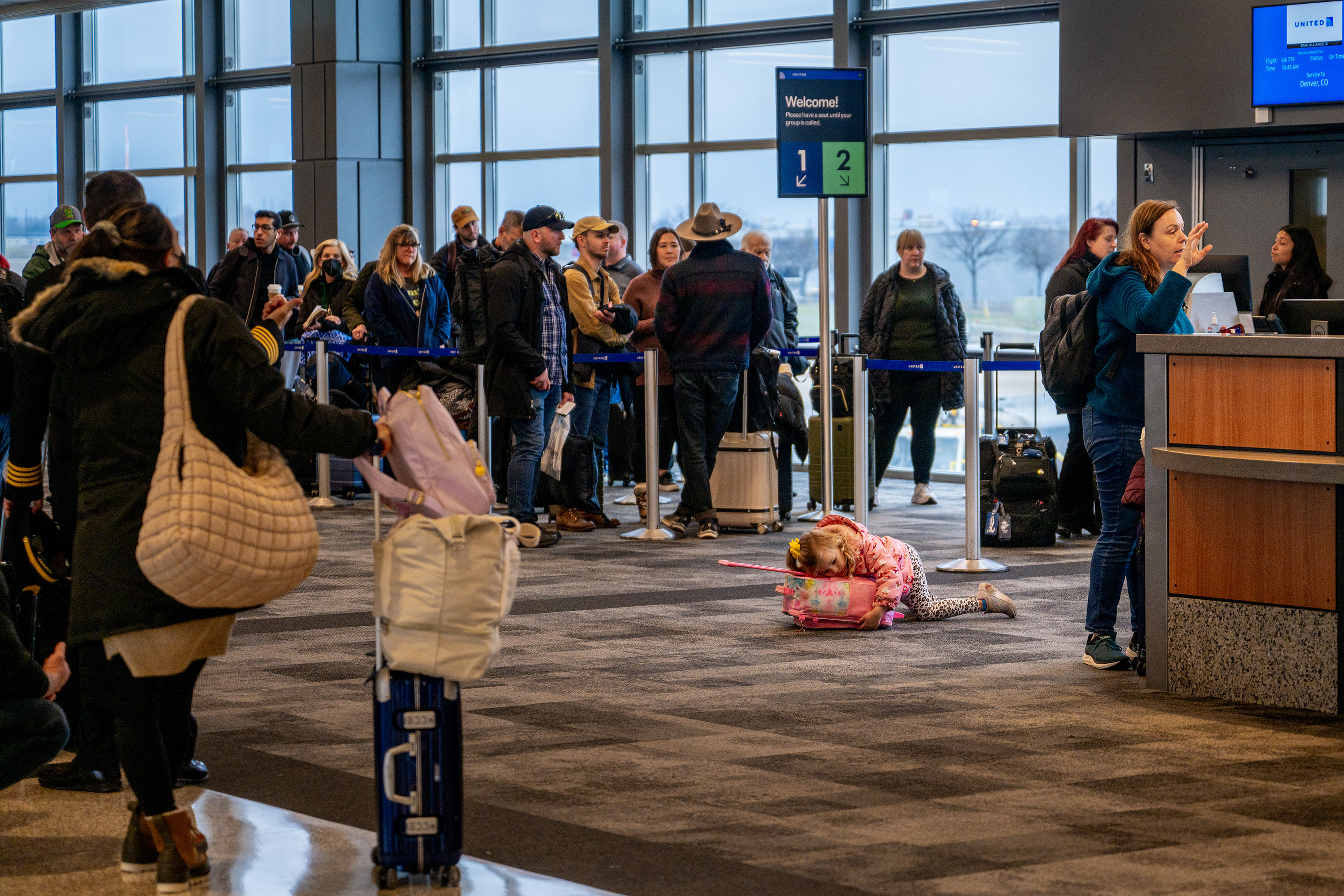 A child lays on some luggage while her parents speaks to gate agents at the Austin Bergstrom International Airport on Monday, Jan. 15, 2024, in Austin, Texas. Airlines across the country continue experiencing mass cancellations and delays as intense storms continue sweeping across the eastern half of the United States. (Brandon Bell/Getty Images/TNS)