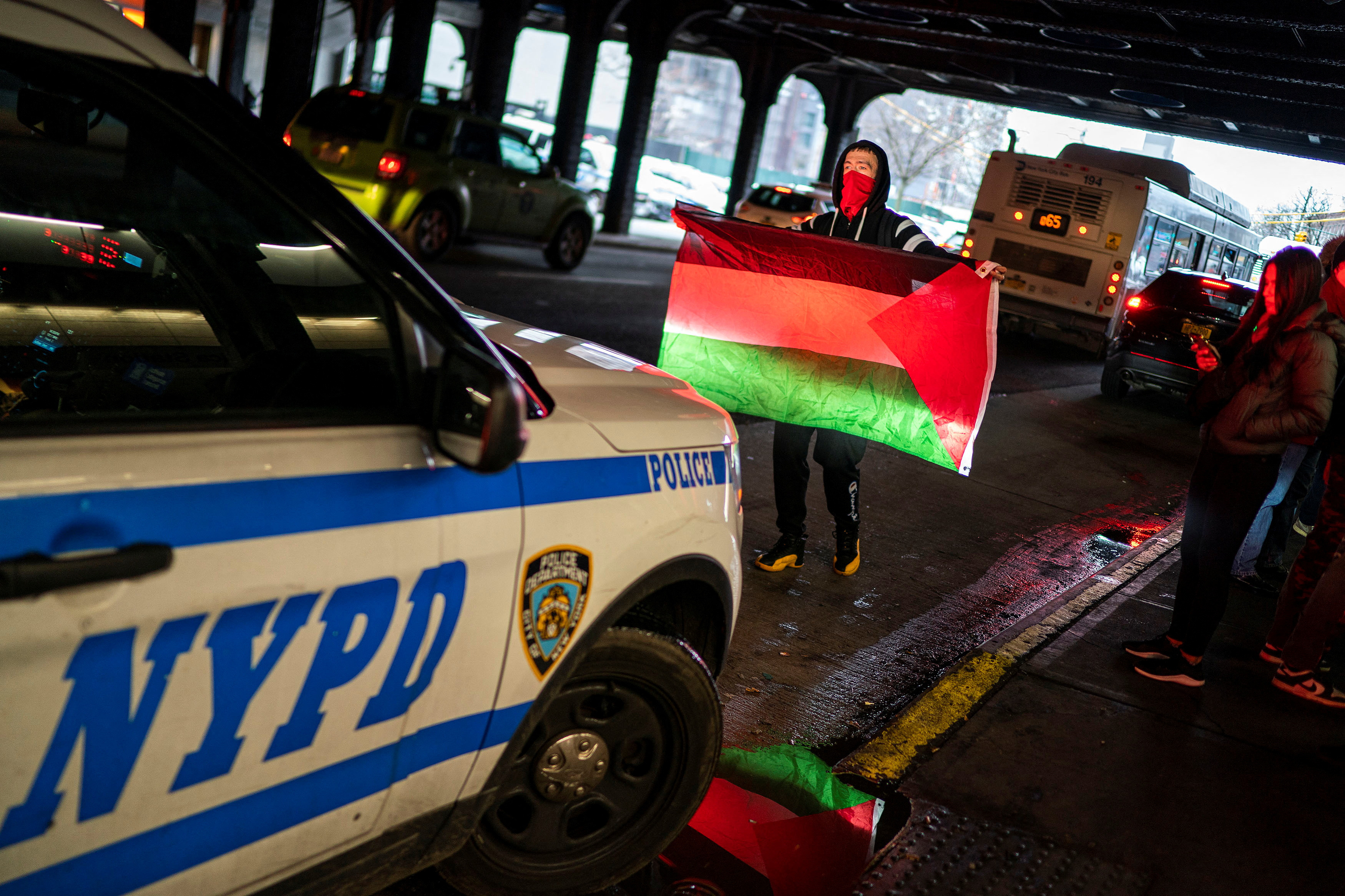 A pro-Palestinian demonstrator tries to stop a NYPD car, as others take part in a protest, outside Jamaica Station to JFK via AirTrain in New York City, U.S., January 27, 2024. 